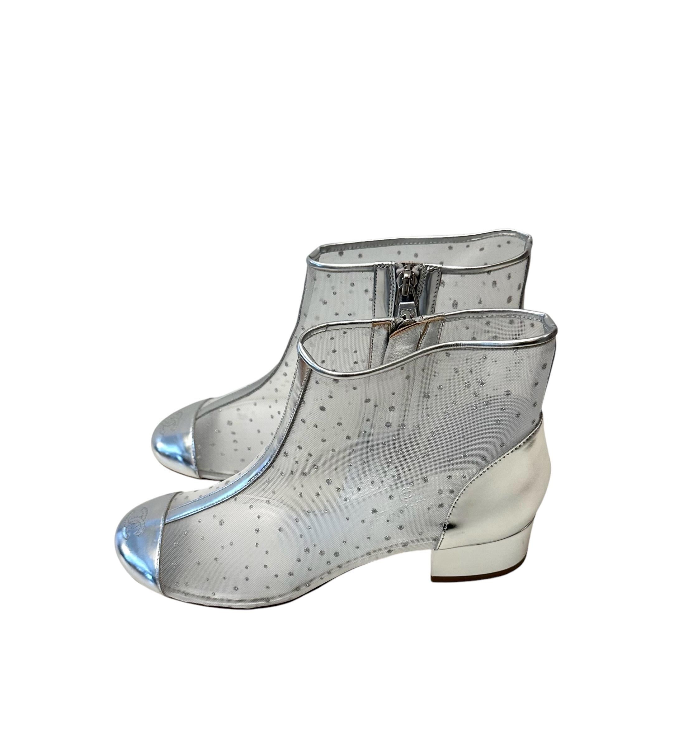 Beautiful new booties from the house of Chanel, crafted in printed mesh and silver mirror calfskin leather.
Round toe in silver leather with CC logo and silver leather ankle and block heel.

Material: Mesh and Calfskin Leather
Color: White and
