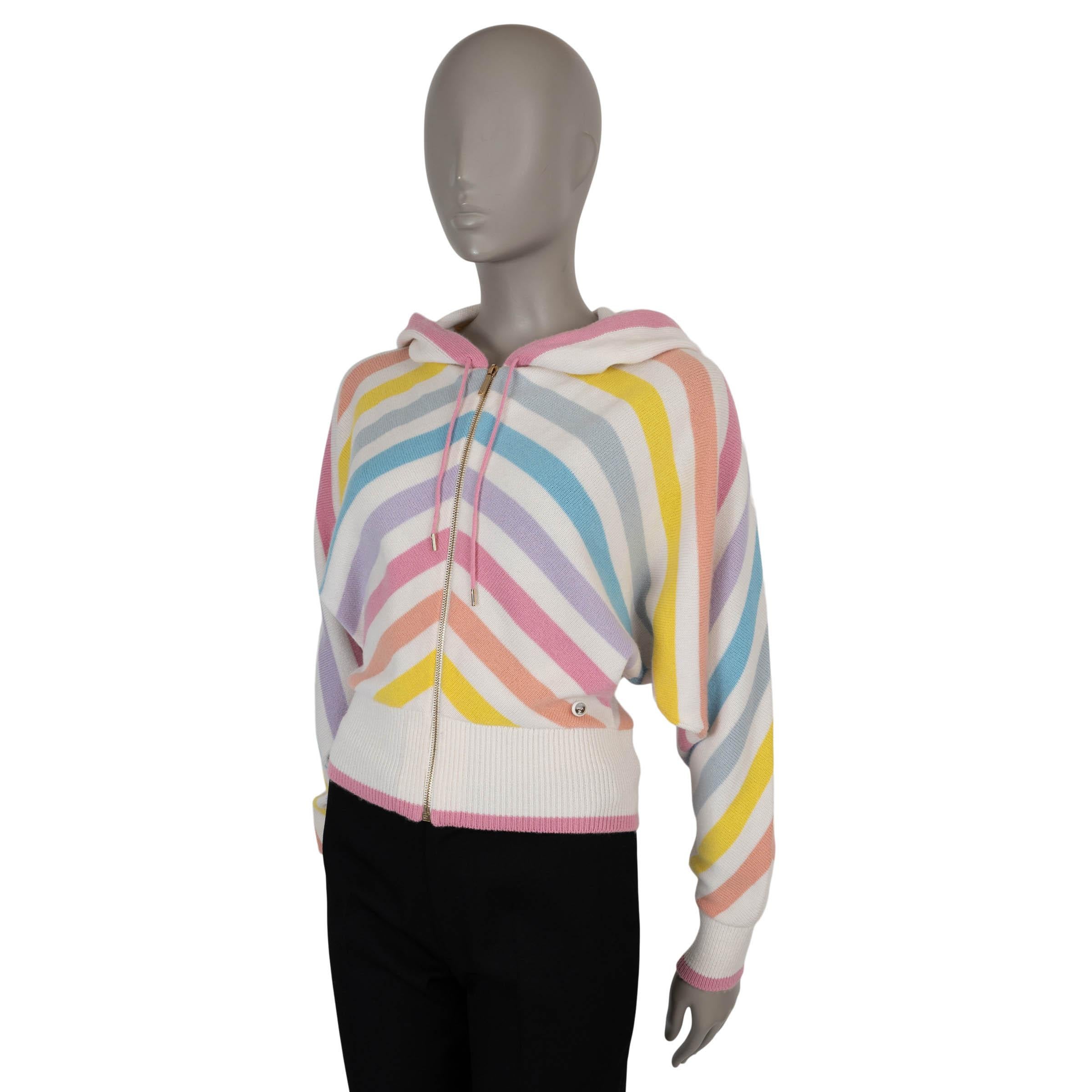 Este cárdigan 100% auténtico Chanel de cachemira a rayas blancas y multicolores (100%) aporta un toque juguetón a las prendas de punto de lujo. Diseñada con una silueta relajada y mangas murciélago, tiene capucha con cordón, ribetes de punto