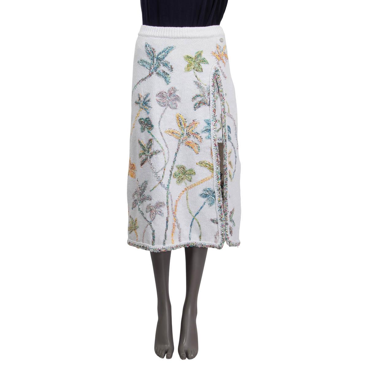 100% authentic Chanel Spring/Summer 2019 midi skirt in white cotton (67%) and linen (32%). Embellished with floral embroideries in green, orange and blue. Features a deep slit and the 'CC' logo on the front side and has an underskirt. Both the slit