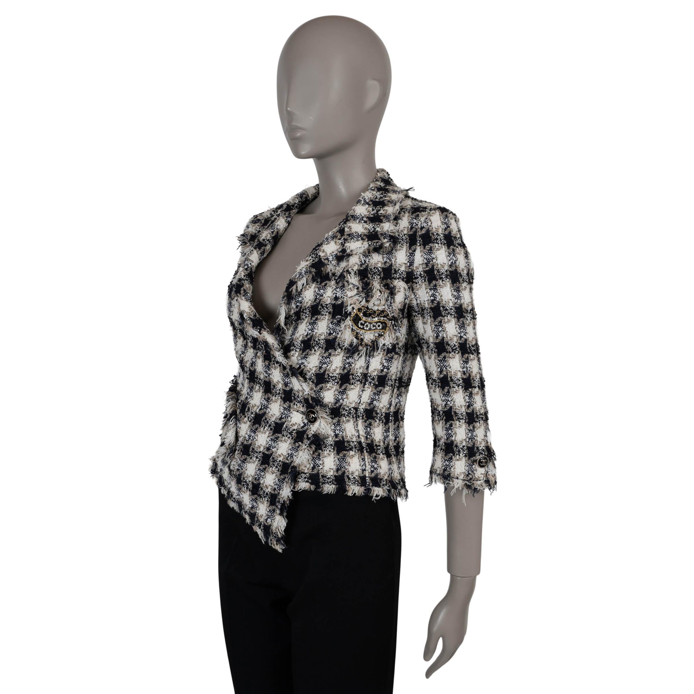 Questa giacca Chanel 100% autentica in cotone tweed a quadri blu, bianco e beige (53%), rayon (21%), nylon (12%), seta (9%) e poliestere (5%) offre un tocco chic a un classico. Disegnato con una silhouette asimmetrica e bordi sfrangiati, è