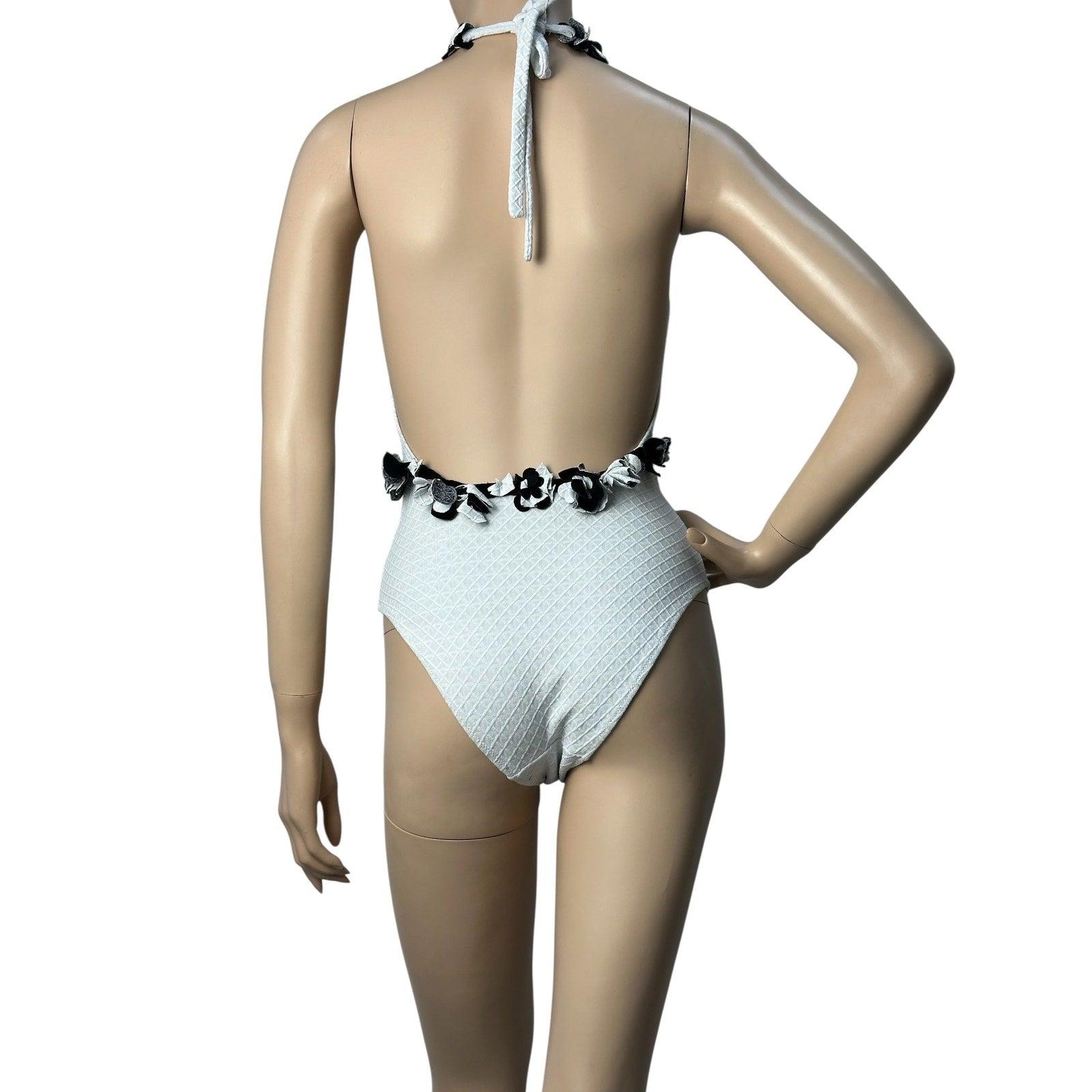 Faites sensation avec ce superbe maillot de bain une pièce blanc de Chanel ! Fabrice en tissu texturé de haute qualité, cet élégant maillot de bain offre à la fois style et confort.
Le chic embellissement floral noir et blanc à l'encolure ajoute une