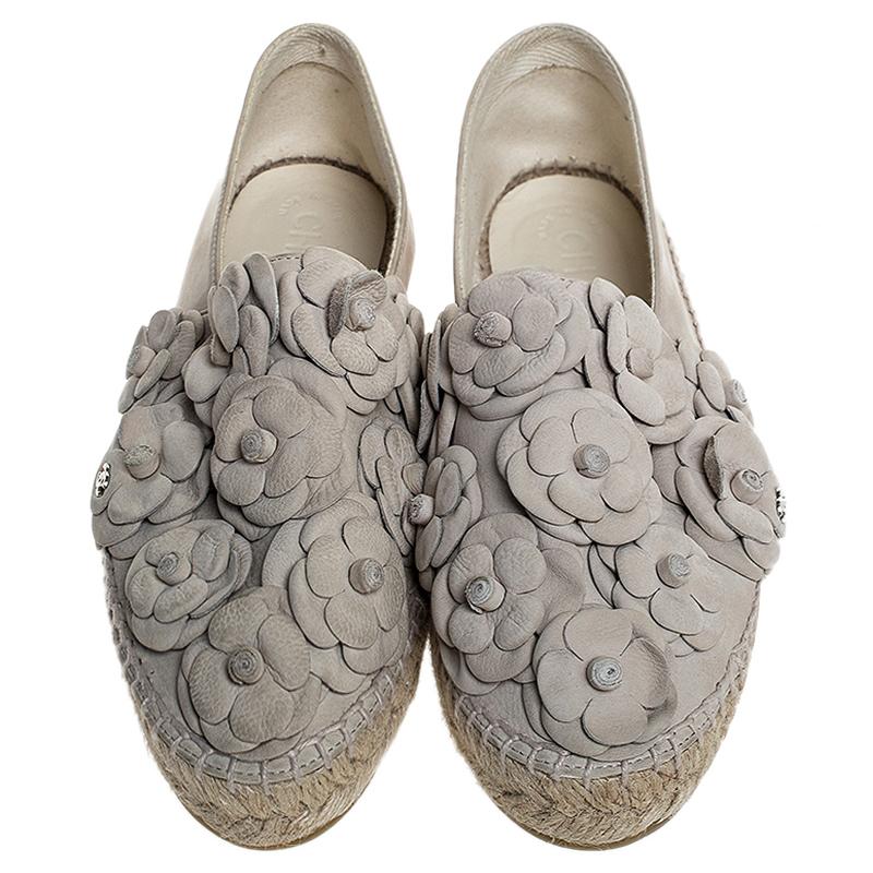 Radiate your fashionable self even in your casuals by owning these espadrilles from Chanel. They've been crafted from nubuck in white while being styled with the signature Camellia flowers all over the vamps and braided details on the midsole. The