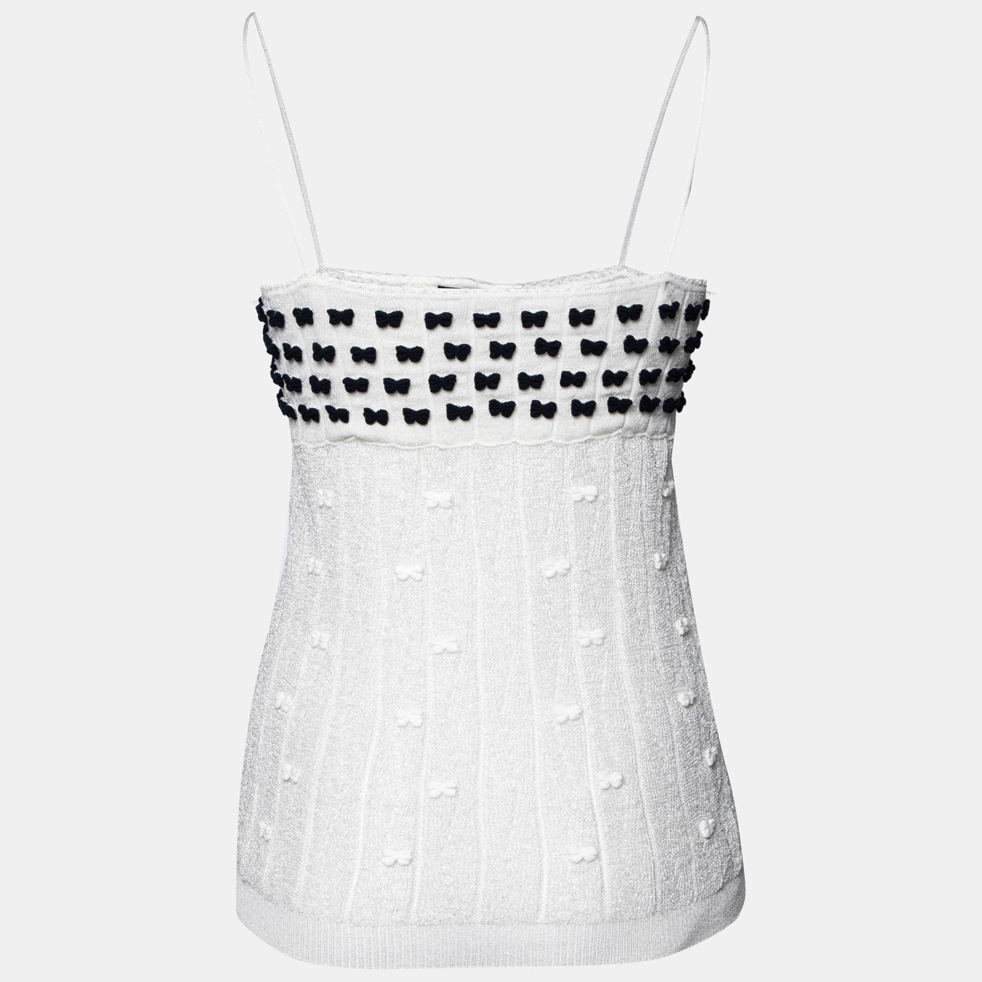Comfortable and appealing, this lovely sleeveless top from Chanel is a must-have clothing item. Created from quality materials, it carries bow motifs that stand out against the white. The creation will pair well with jeans, skirts, and tailored