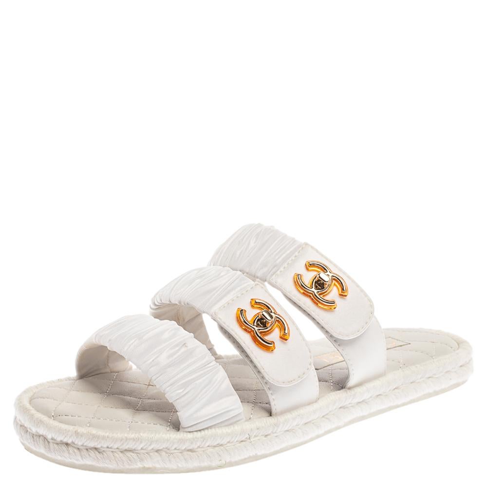 Make your feet smile with these slide flats from Chanel! The white flats are crafted from pleated fabric and feature an open toe silhouette. They have been styled with three straps across the vamps, two of which flaunt the iconic CC turn-lock in