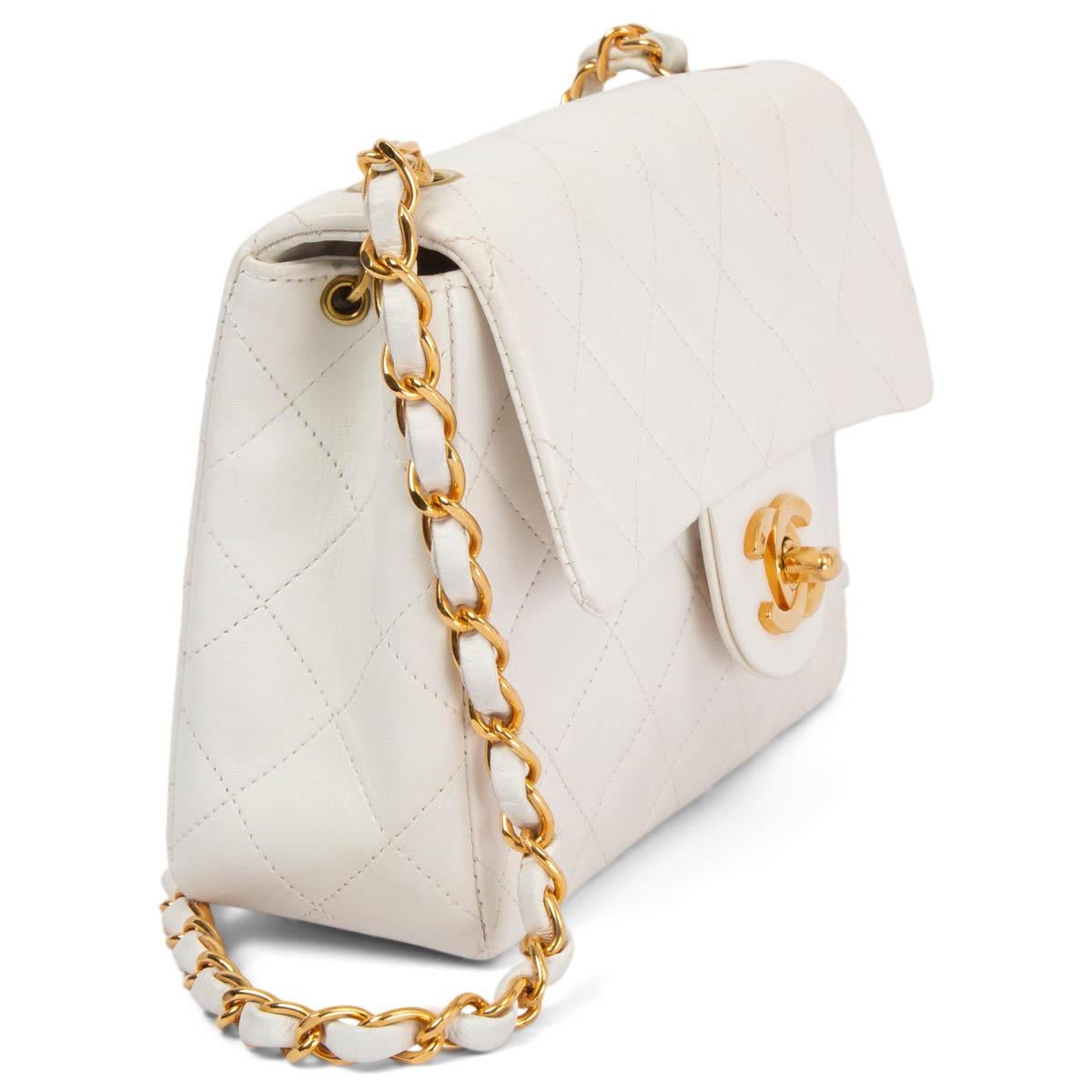 100% authentic Chanel 1997-1999 Mini Square Flap Shoulder Bag in white quilted lambskin featuring gold-tone hardware. Opens with the classic CC turn-lock to a white leather lined interior with one zipper pocket and one open pocket against the back.