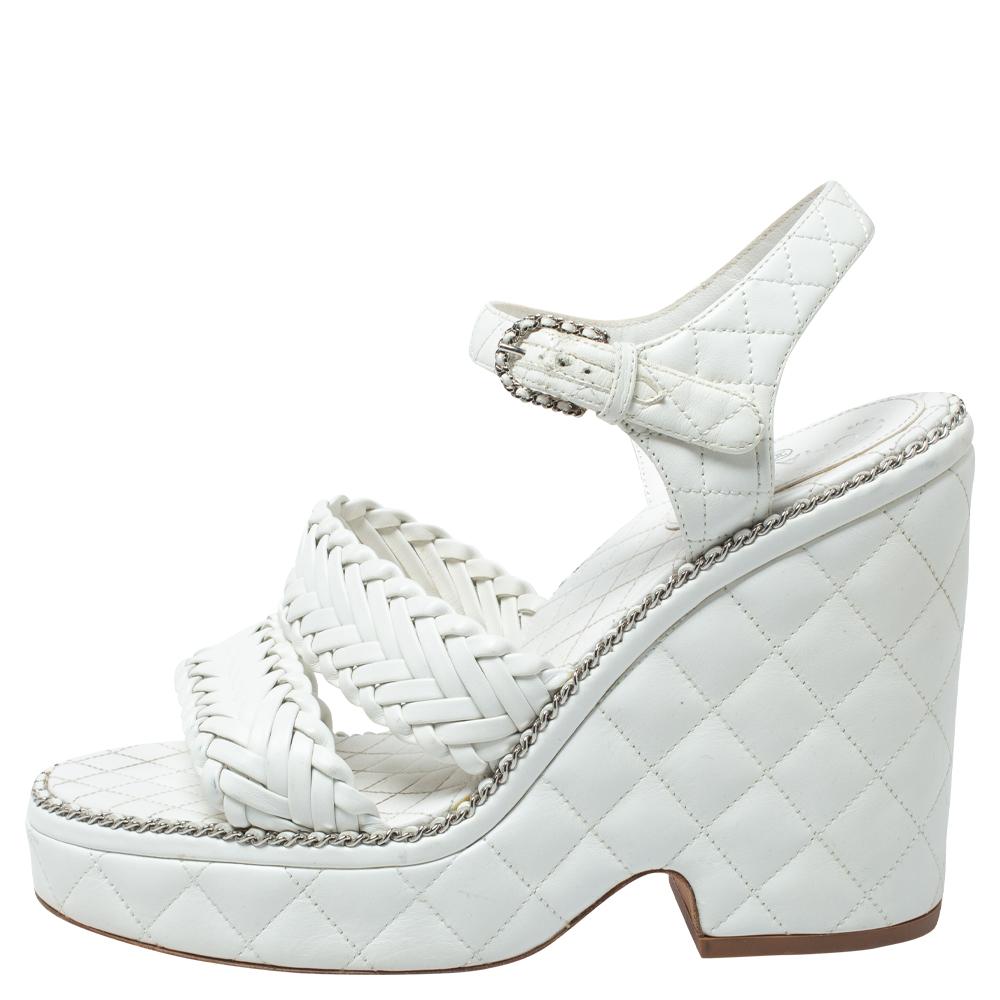 Siempre habrá sitio en el armario de una mujer para un par de zapatos de Chanel. Aquí tenemos un precioso par en piel blanca. Las sandalias están acolchadas y llevan tiras tejidas, cierre de hebilla y tacones de 12 cm sostenidos por plataformas.

