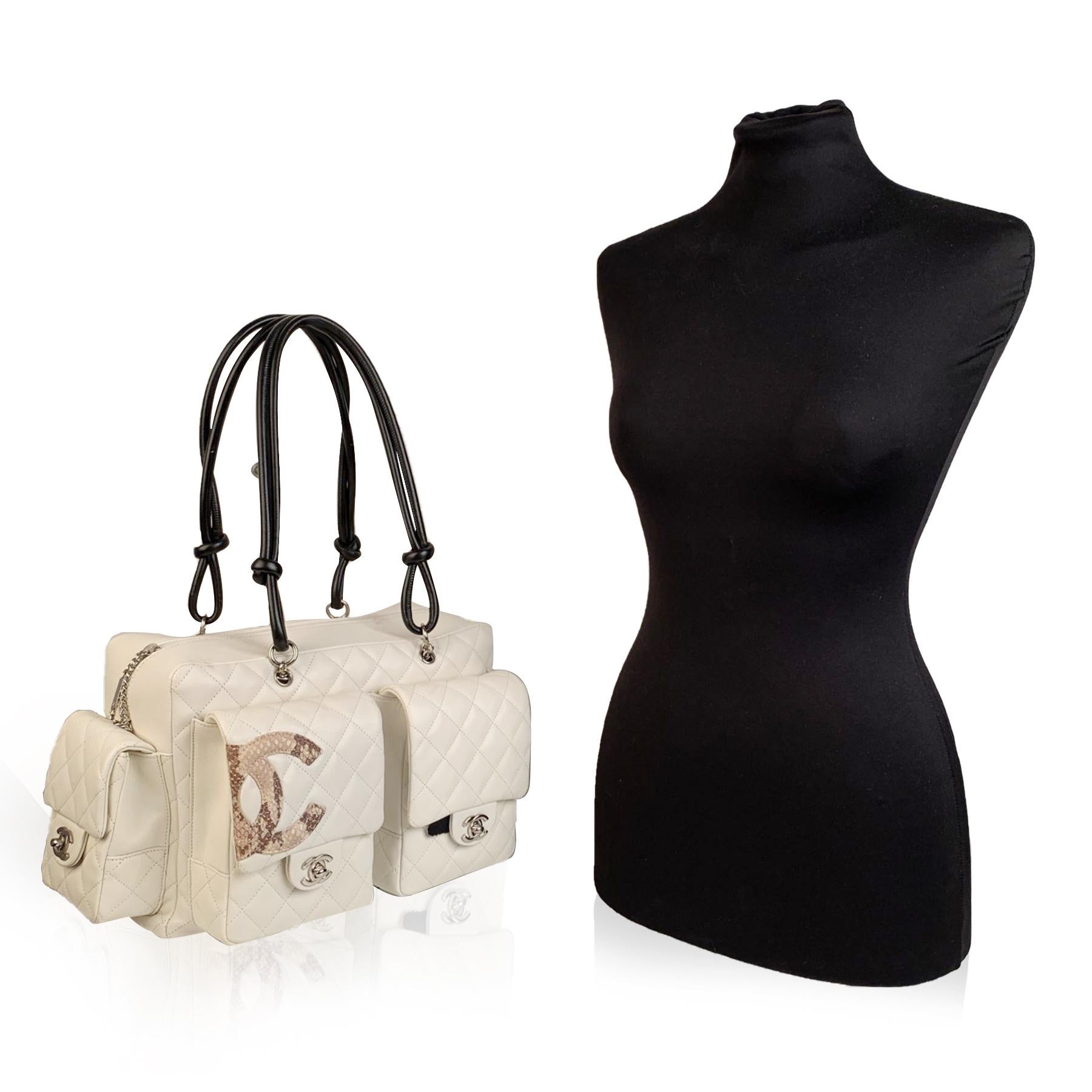 This bag will come with a Certificate of Authenticity provided by Entrupy, at no further cost.

Sophisticated and practical Chanel Ligne Cambon Reporter Bag. White quilted leather, detailed with a beige python leather Chanel CC logo. Upper zipper