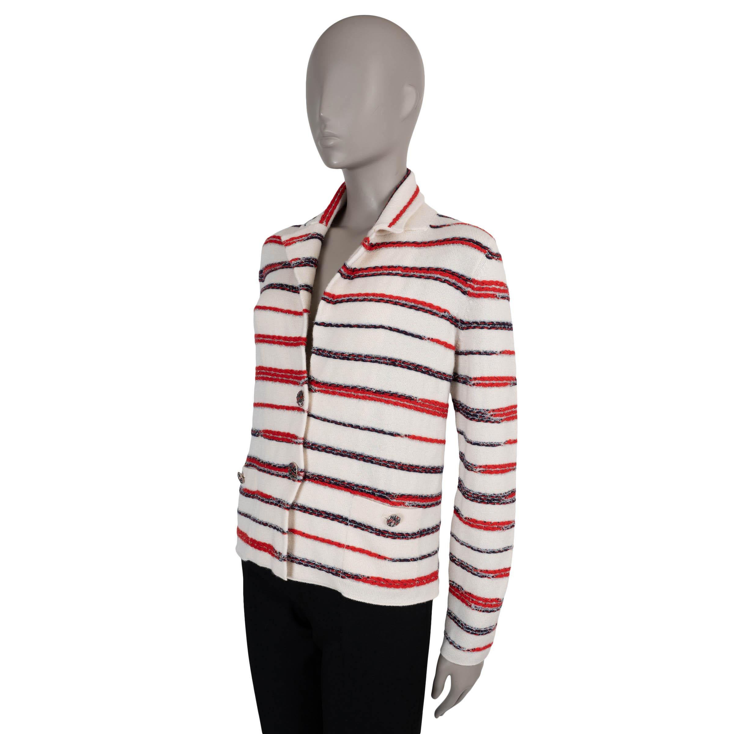 Questa giacca Chanel 100% autentica in cashmere lavorato a maglia bianca (100%) è un suggestivo richiamo all'eleganza nautica. Progettato con una silhouette aderente, sfoggia audaci strisce blu navy e rosse a maglia grossa intrecciate con orpelli