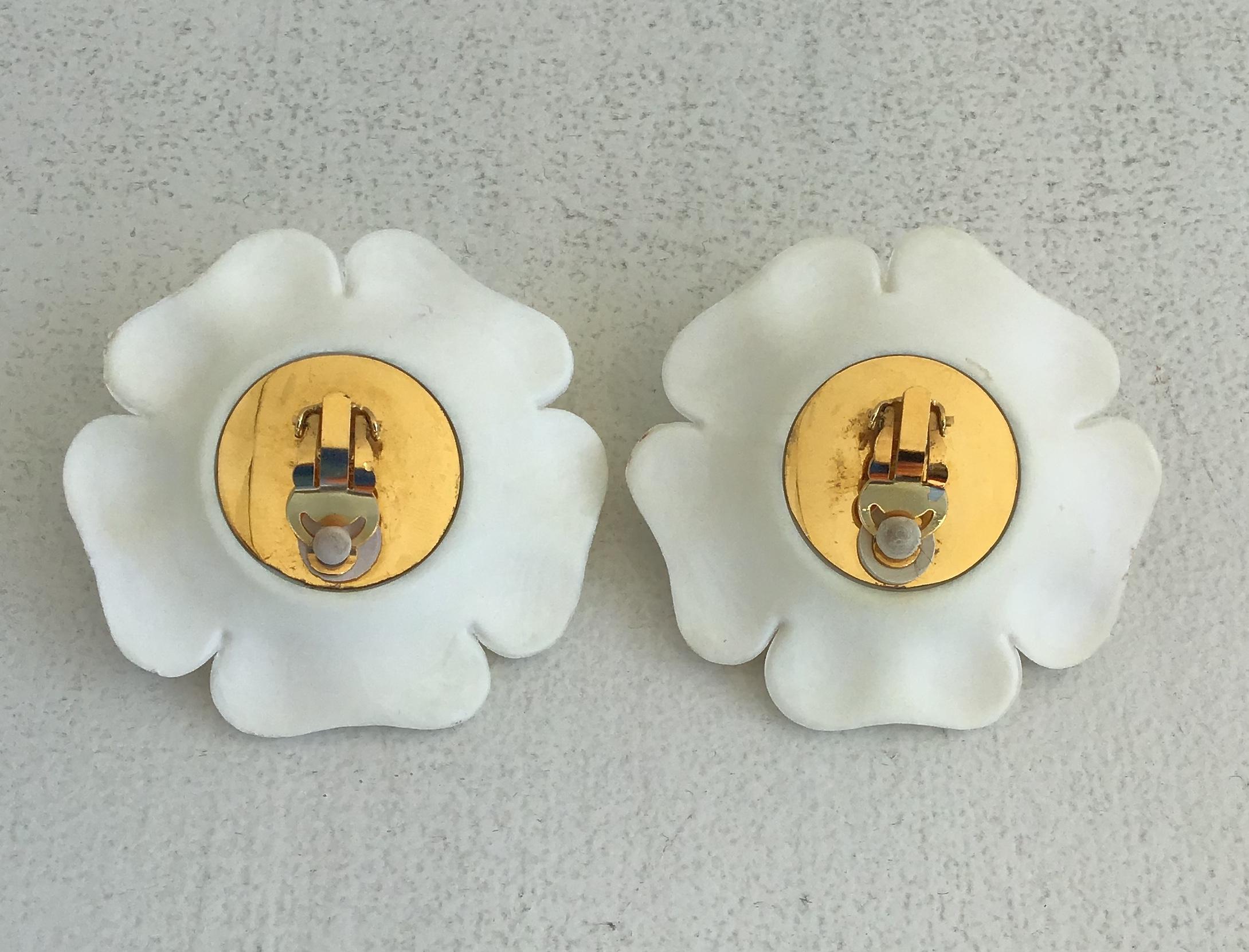 Chanel White Resin Flower Clip on Earrings. Large white molded plastic pedals with gold center. and gold tone brass backing. Padded clips indicated on backside.