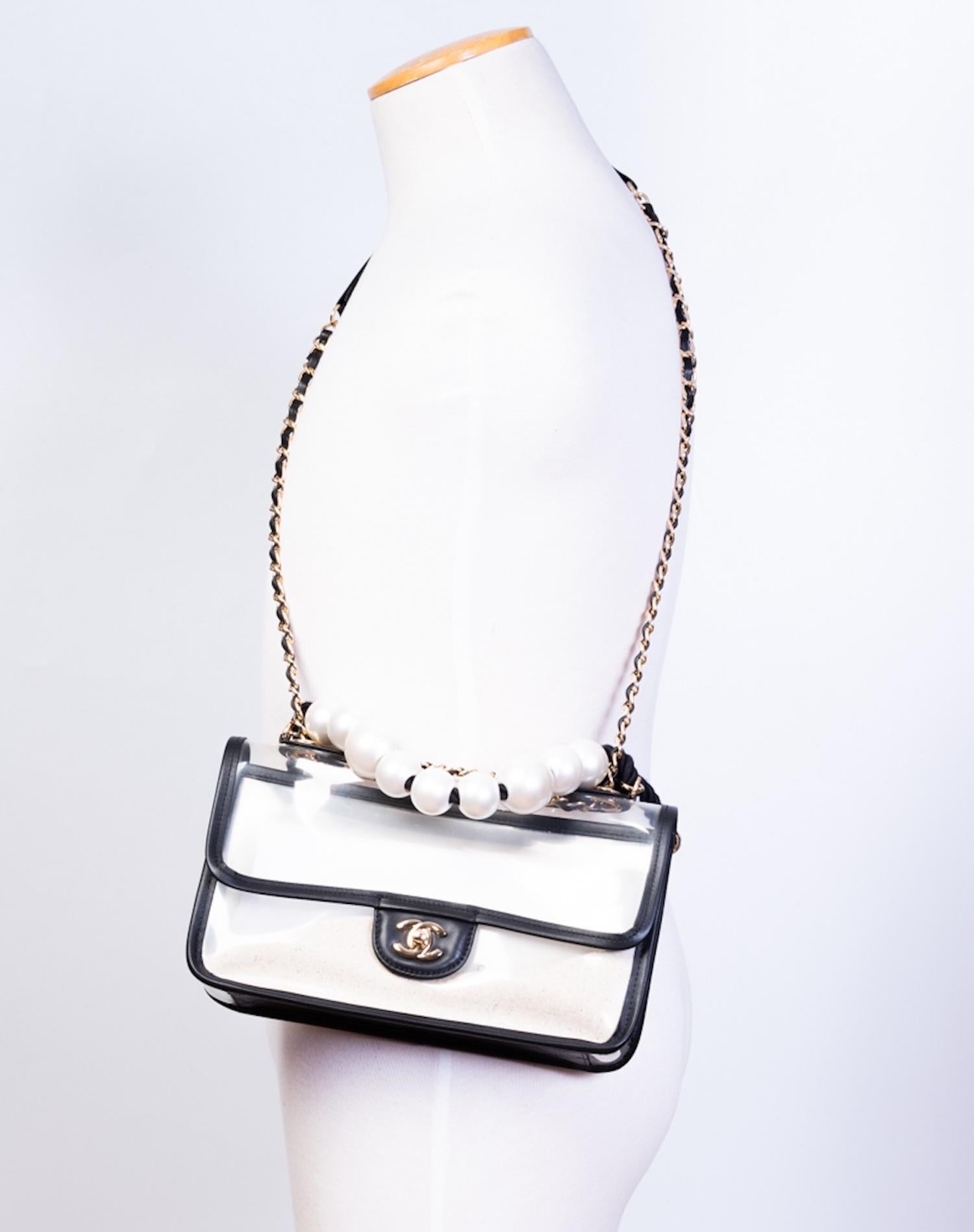 CHANEL WHITE SAND PVC BY THE SEA FLAP BAG AS IS

The Chanel Sand By The Sea flap bag from 2019 is made of transparent PVC with black lambskin leather trim. The body features flowing sand that moves with the bag, complemented by a back slip pocket.