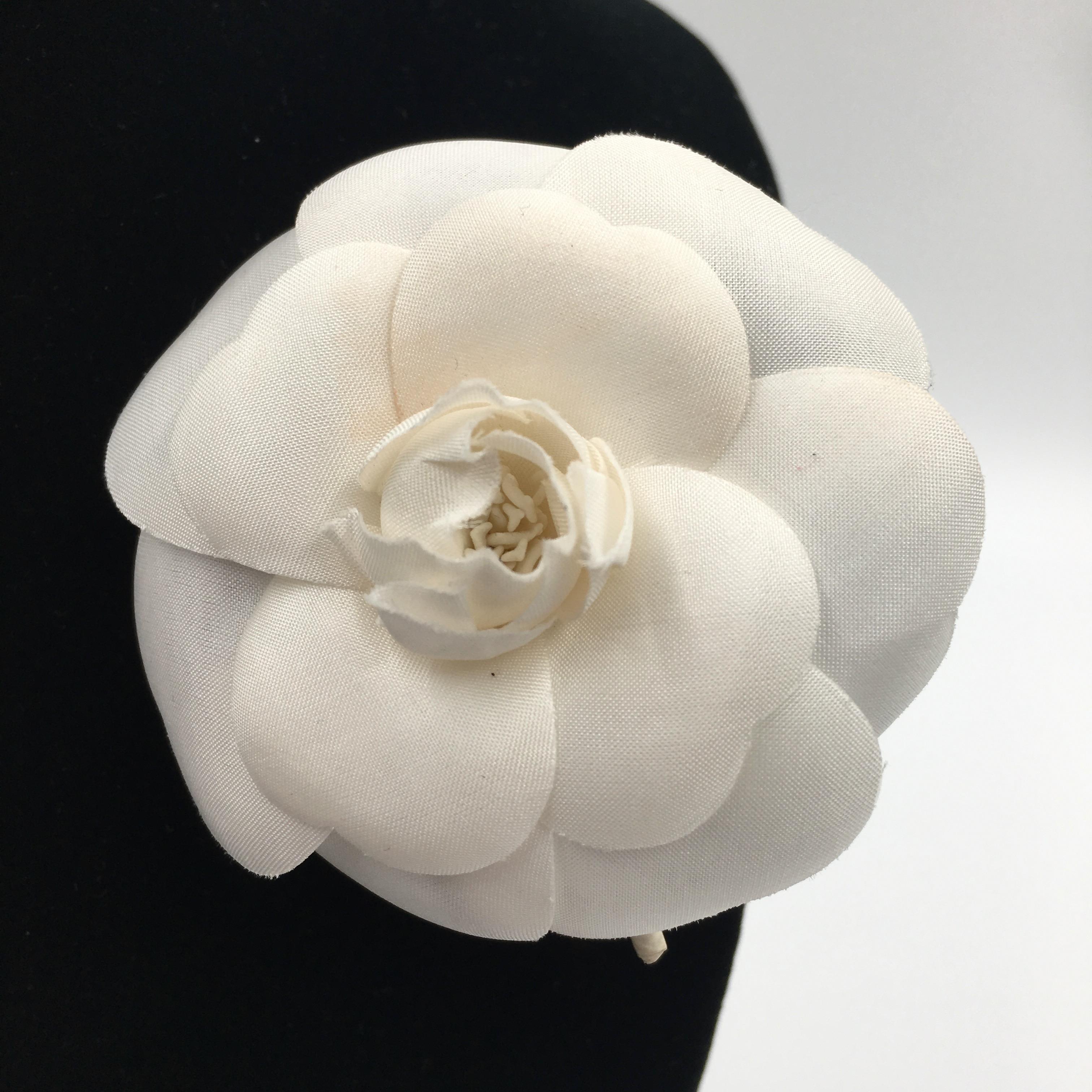 Chanel White Silk Camellia Brooch .  Chanel tag attached to back by pin backing. 
Chanel box not included

Good vintage condition.

Measurements are as follows:

Flower width 2 3/4
