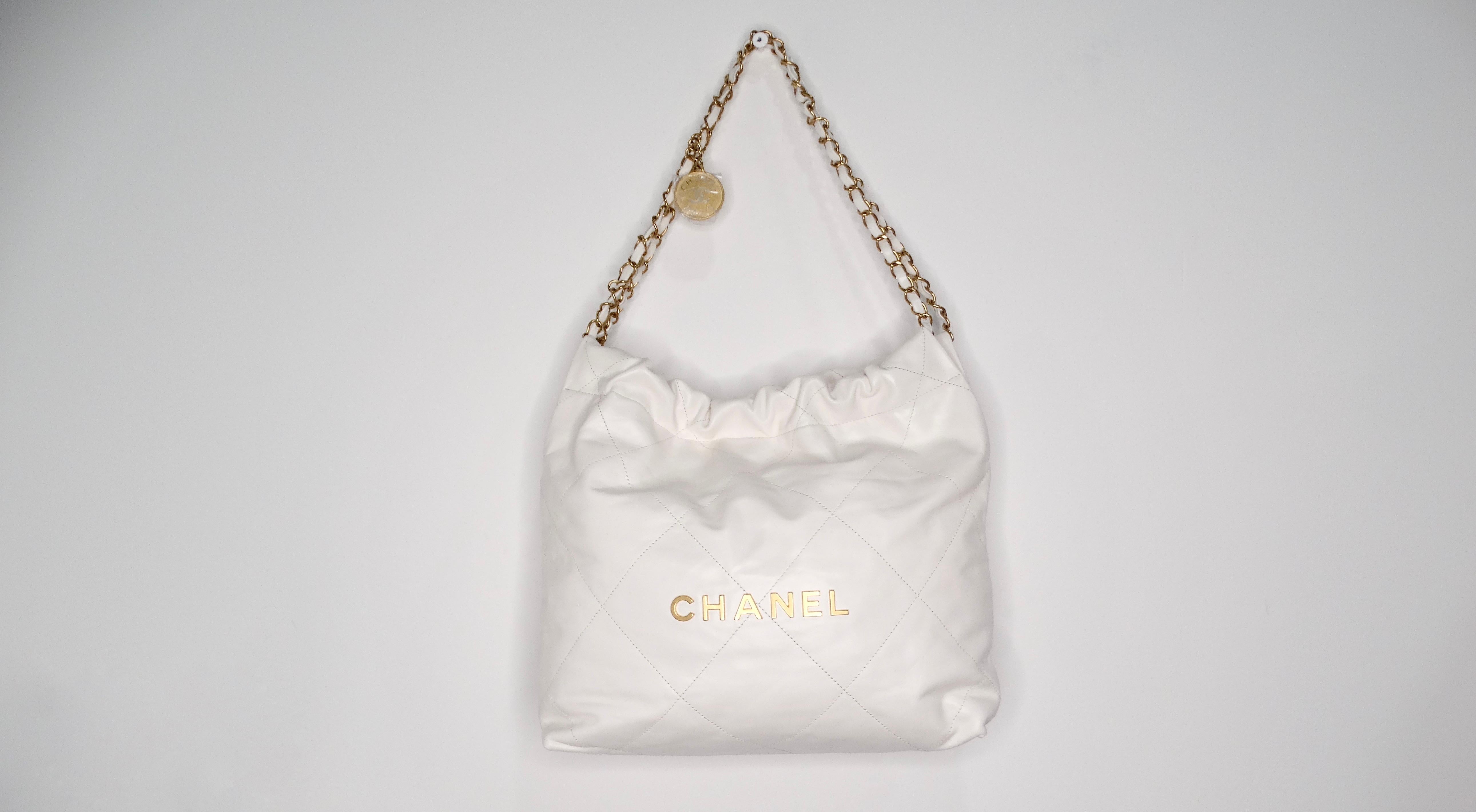 The Chanel White Small 22 Shiny Calfskin Leather Hobo Bag is a stunning embodiment of luxury and sophistication. This versatile accessory features a sleek, curved shape crafted from high-quality shiny calfskin leather, delivering both style and