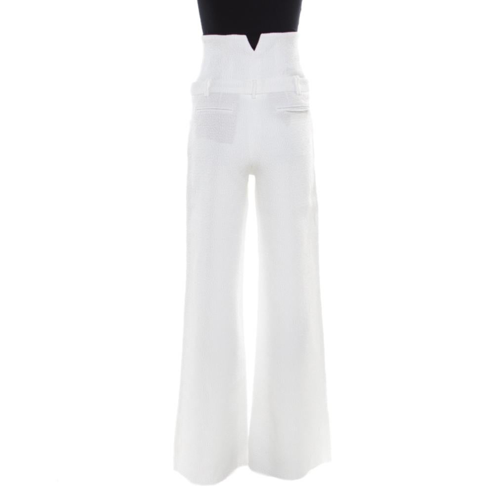 Chanel's elegant white trousers are designed with wide legs. They are crafted with a cotton blend and have a textured finish. The easing silhouette of these trousers makes them a comfortable piece of clothing which, when paired with a fitted blouse,