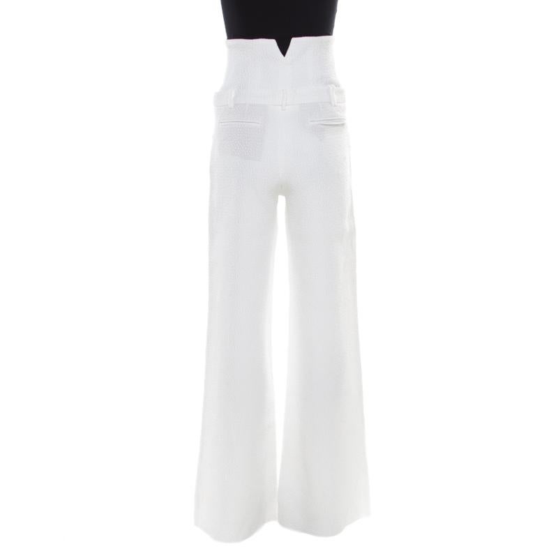 Chanel's elegant white trousers are designed with wide legs. They are crafted with a cotton blend and have a textured finish. The easing silhouette of these trousers makes them a comfortable piece of clothing which, when paired with a fitted blouse,