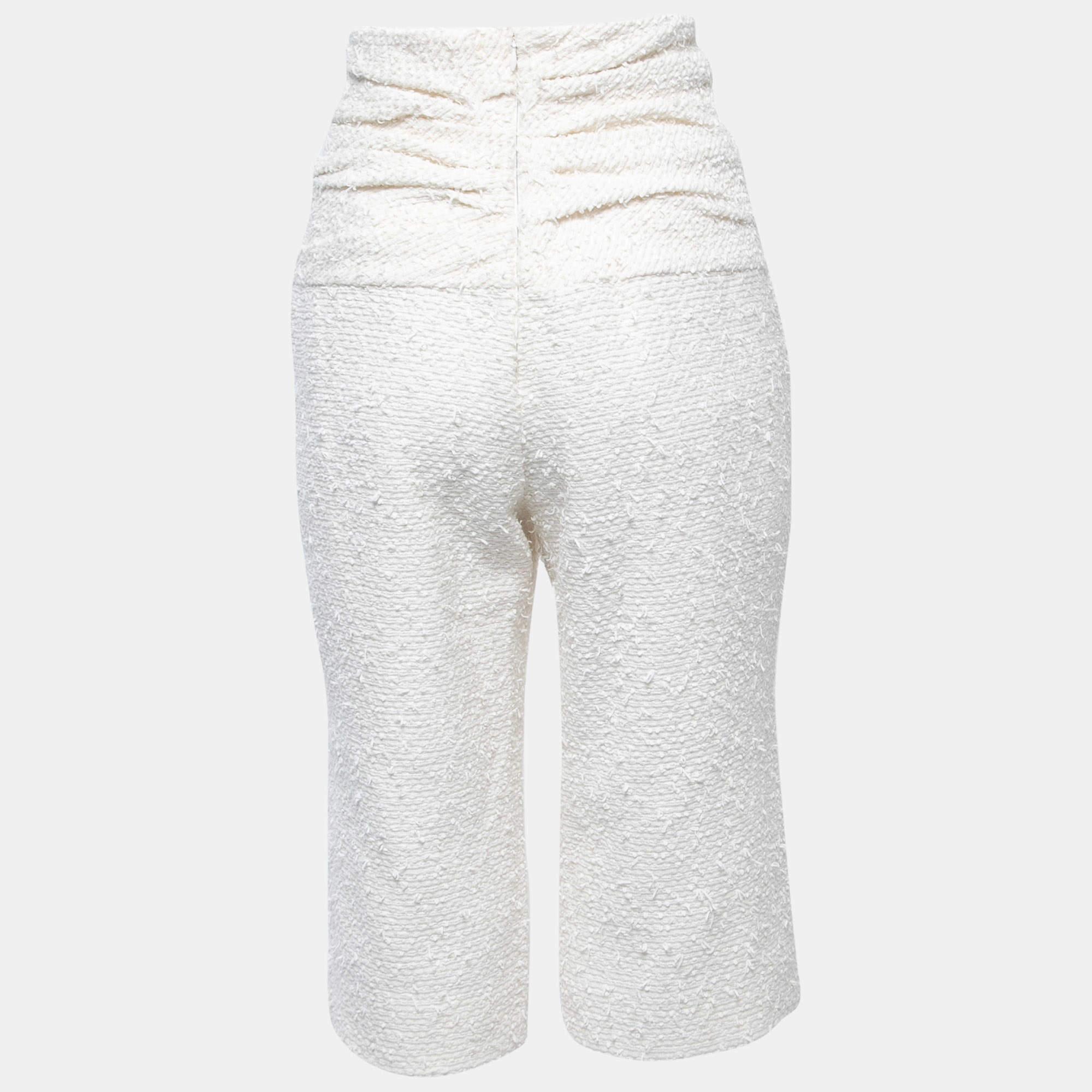 Chanel pants are a luxurious fashion statement. Crafted from high-quality white tweed fabric, they feature a flattering slim fit, a mid-calf length, and iconic Chanel logo buttons. These pants exude timeless elegance, making them a versatile