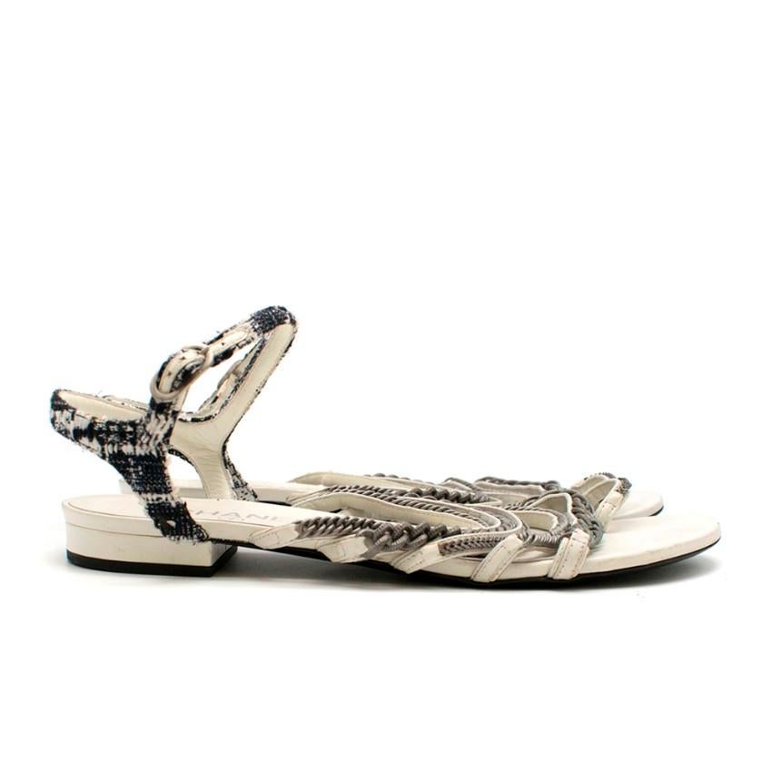 Chanel White Flat Sandals

- Toe strap
- Multiple straps
- Tweed ankle strap 
- Silver tone buckle fastening
- Metal chain hardware

Material
- Leather insole
- Leather sole

Made in Italy

Mini heel: 2.3 cm
Insole: 27 cm
Width: 9.5 cm