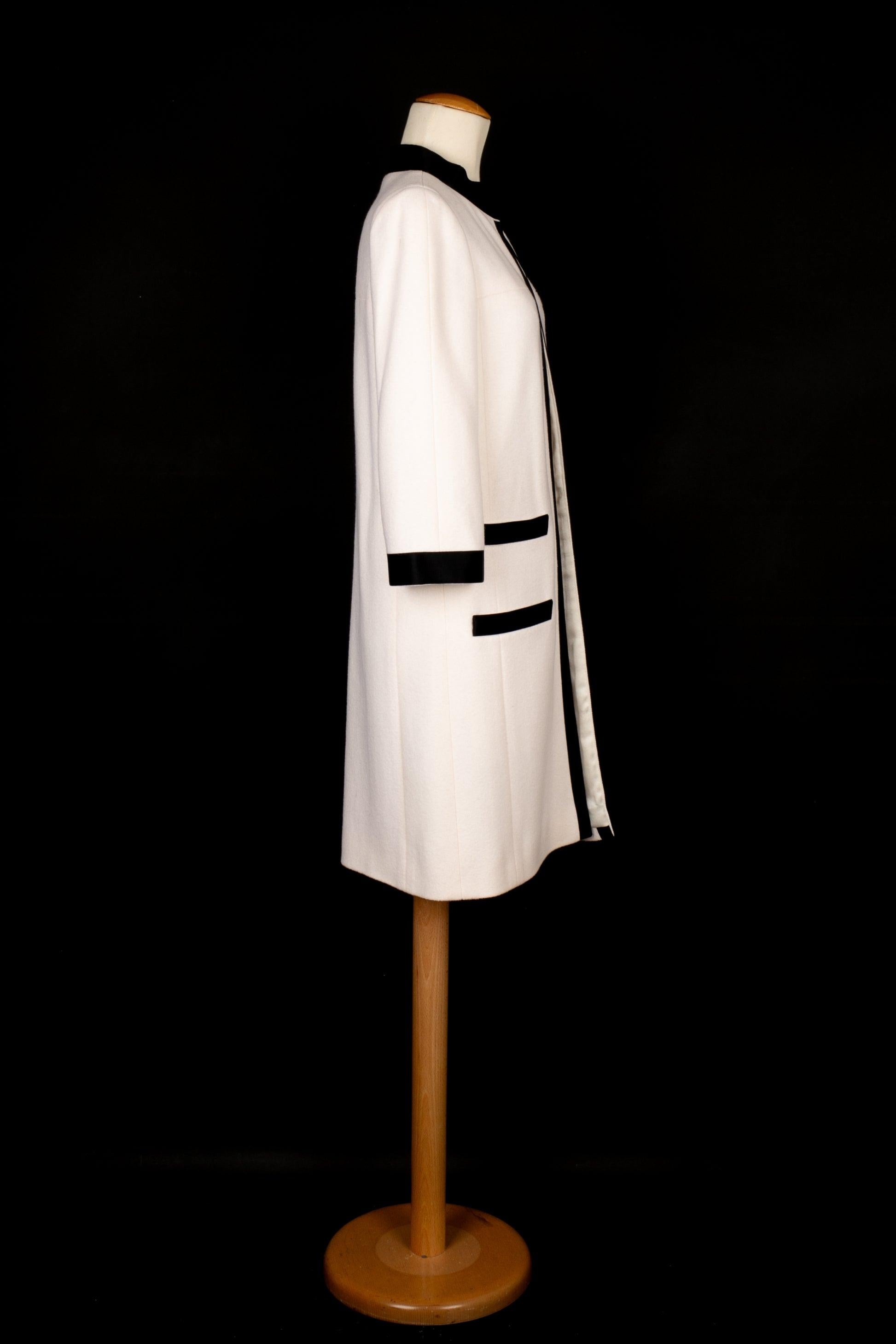 Chanel - (Made in France) White wool coat edged with black satin braids. Silk lining. Size 34FR. 2005 Fall-Winter Collection under the artistic direction of Karl Lagerfeld.

Additional information:
Condition: Very good condition
Dimensions: Shoulder