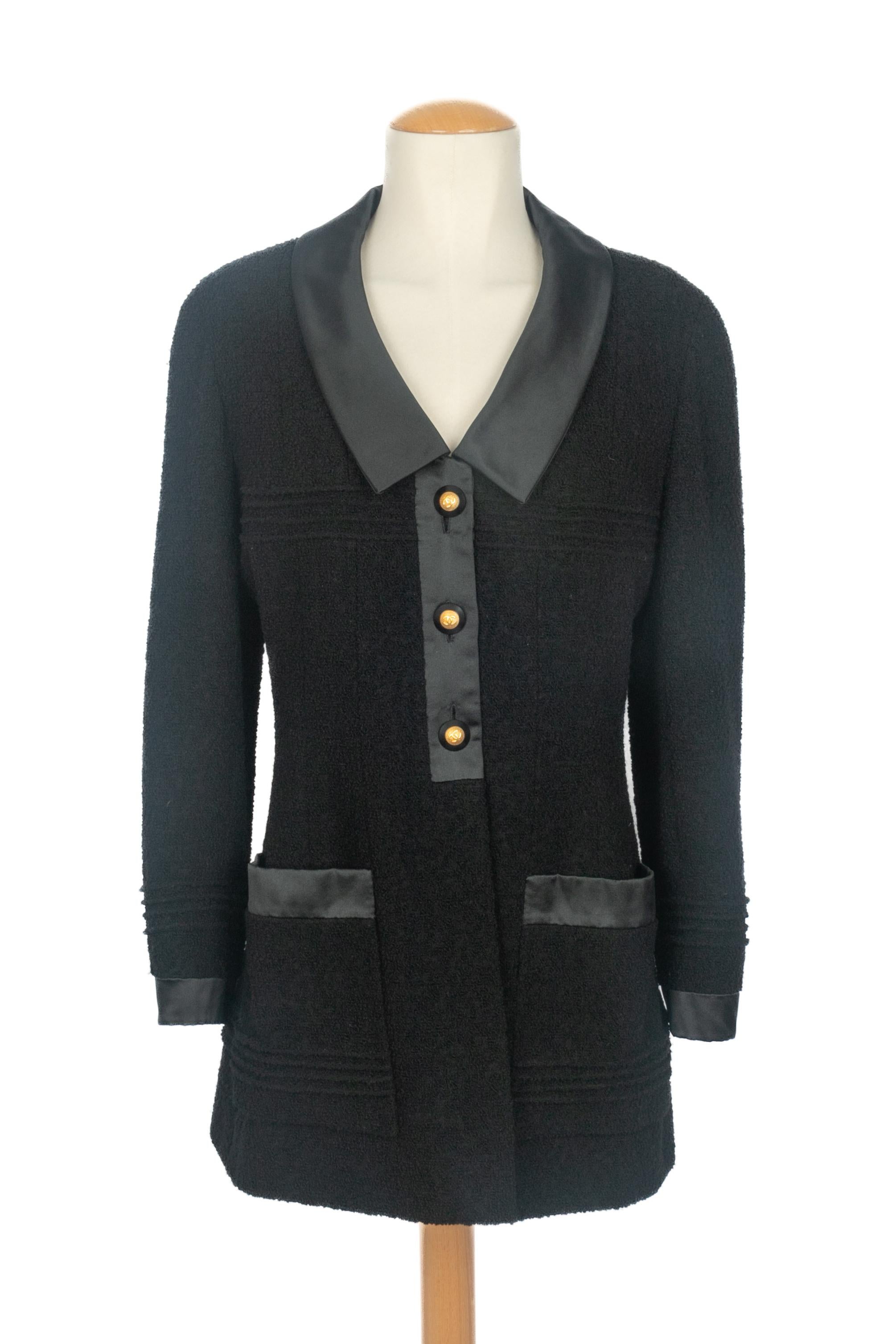 Chanel - (Made in France) Giacca in lana nera di media lunghezza rifinita con raso nero e bottoni in metallo dorato. Taglia 42FR. Collezione Autunno/Inverno 1993 sotto la direzione artistica di Karl Lagerfeld.

Condizioni:
Ottime