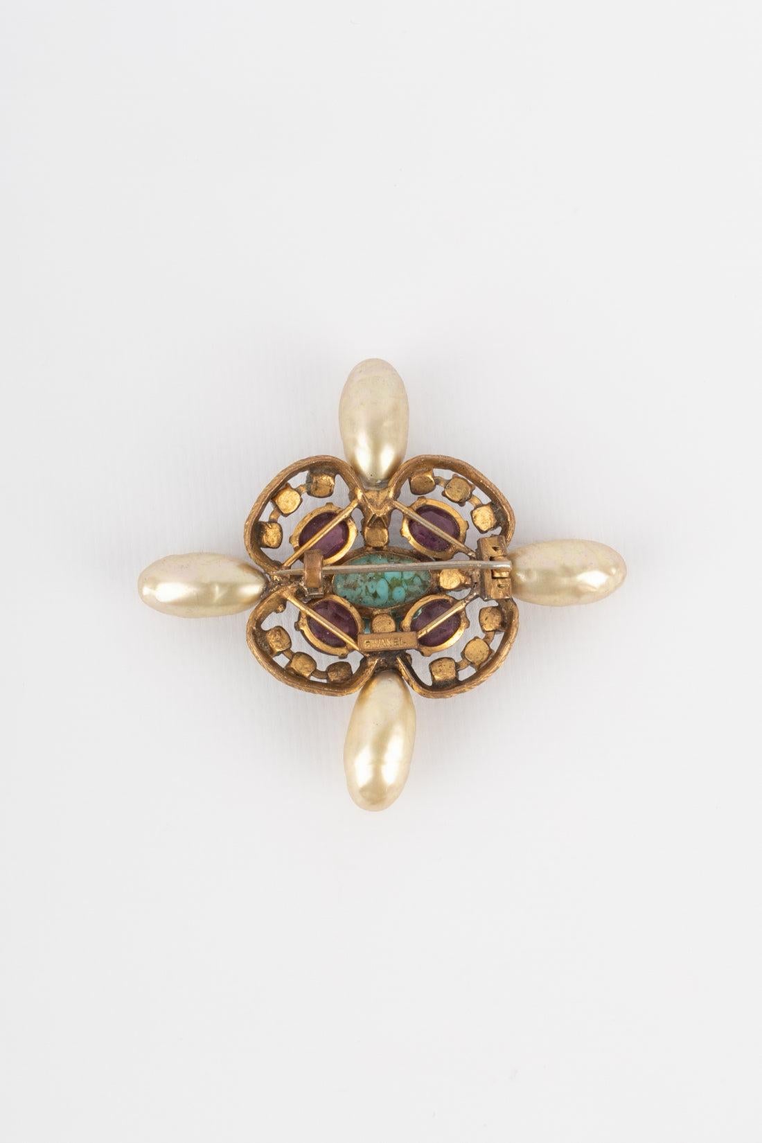 Chanel  - Broche en métal doré ornée d'une perle de verre, de strass et de gouttes nacrées. Collection Sal de Haute Couture de l'époque de Coco.
Informations complémentaires :
Condit : Très bon état.
Dimensions : Hauteur : 7 cm

Référence du vendeur