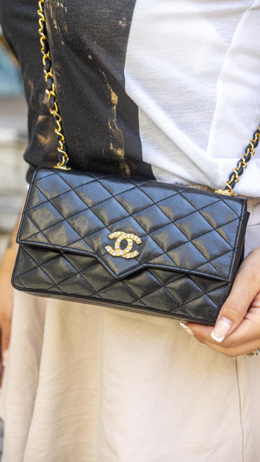 Borsa firmata Chanel, modello Woc vintage, realizzata in pelle nera liscia con hardware dorati. Dotata di una patat con chiusura ad incastro, internamente rivestita in pelle bordeaux, capiente per l’essenziale. Munita di una  tracolla in pelle e