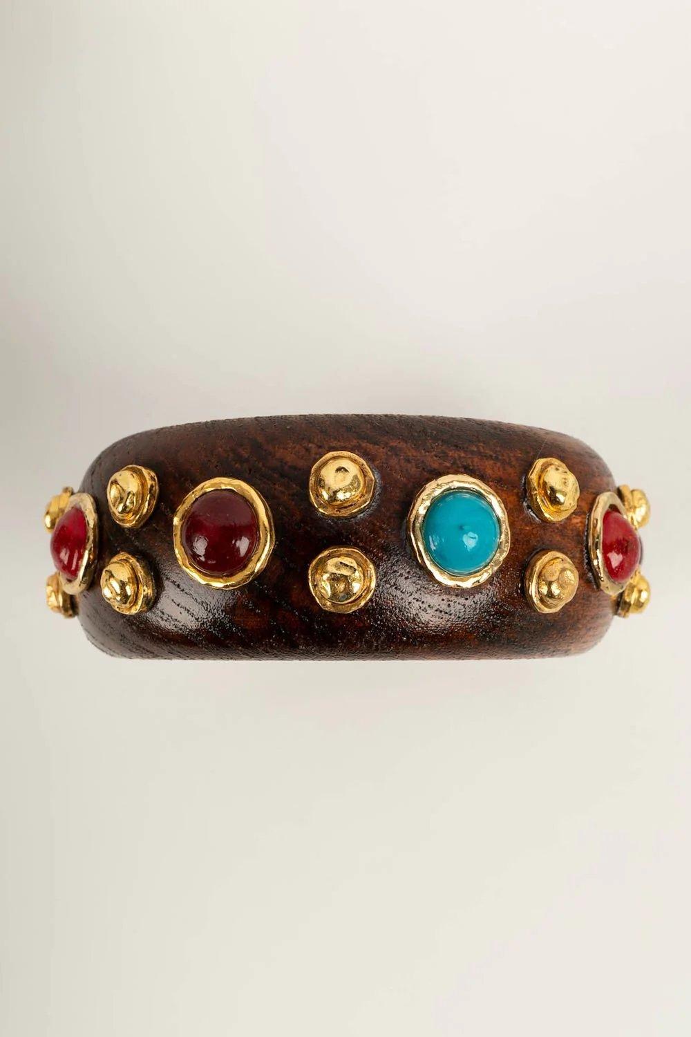 Chanel -(Made in France) Wooden and golden metal bracelet paved with multicolored cabochons.

Additional information:

Dimensions: Diameter: 7 cm 
Circumference: 20.5 cm

Condition: Very good condition

Seller Ref number: BRAB163