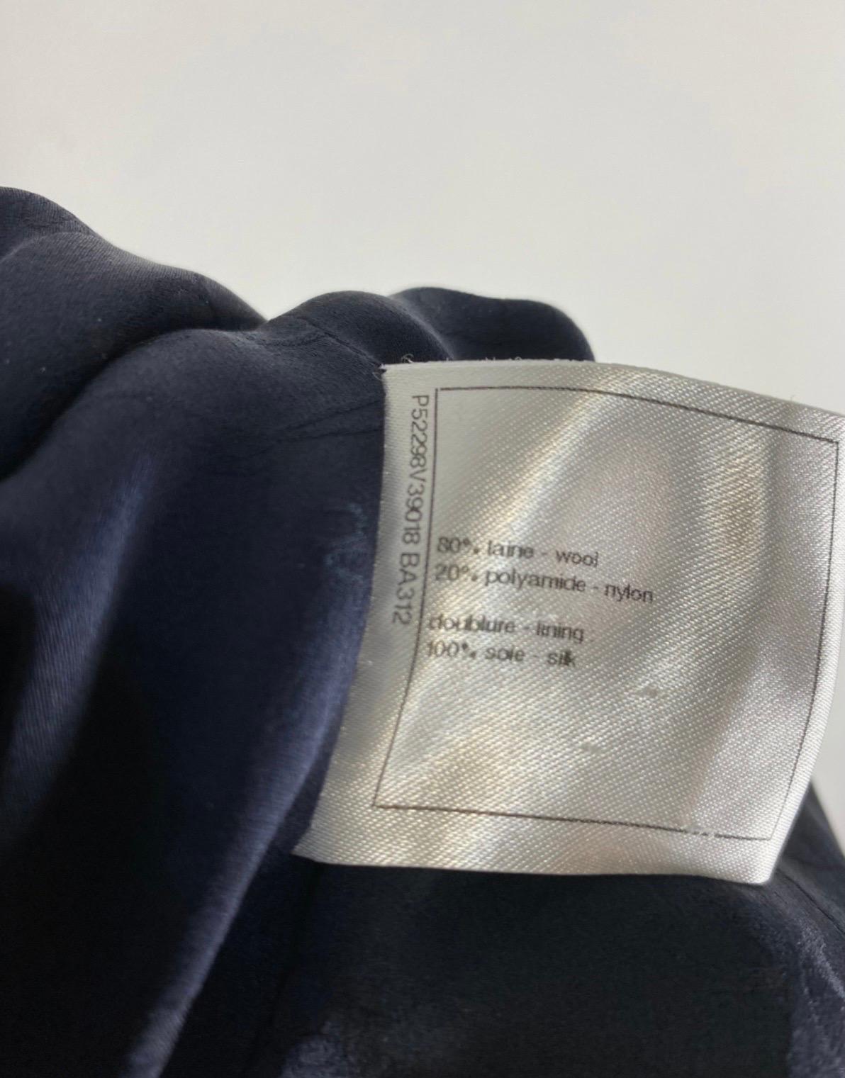 Veste Chanel taille 34 française donc 38Italienne, en laine bleue travaillée comme une boucle, avec une fermeture particulière sur le devant, au dos à la place les 2 fentes latérales sont enrichies de deux boutons, veste longue, le seul défaut est