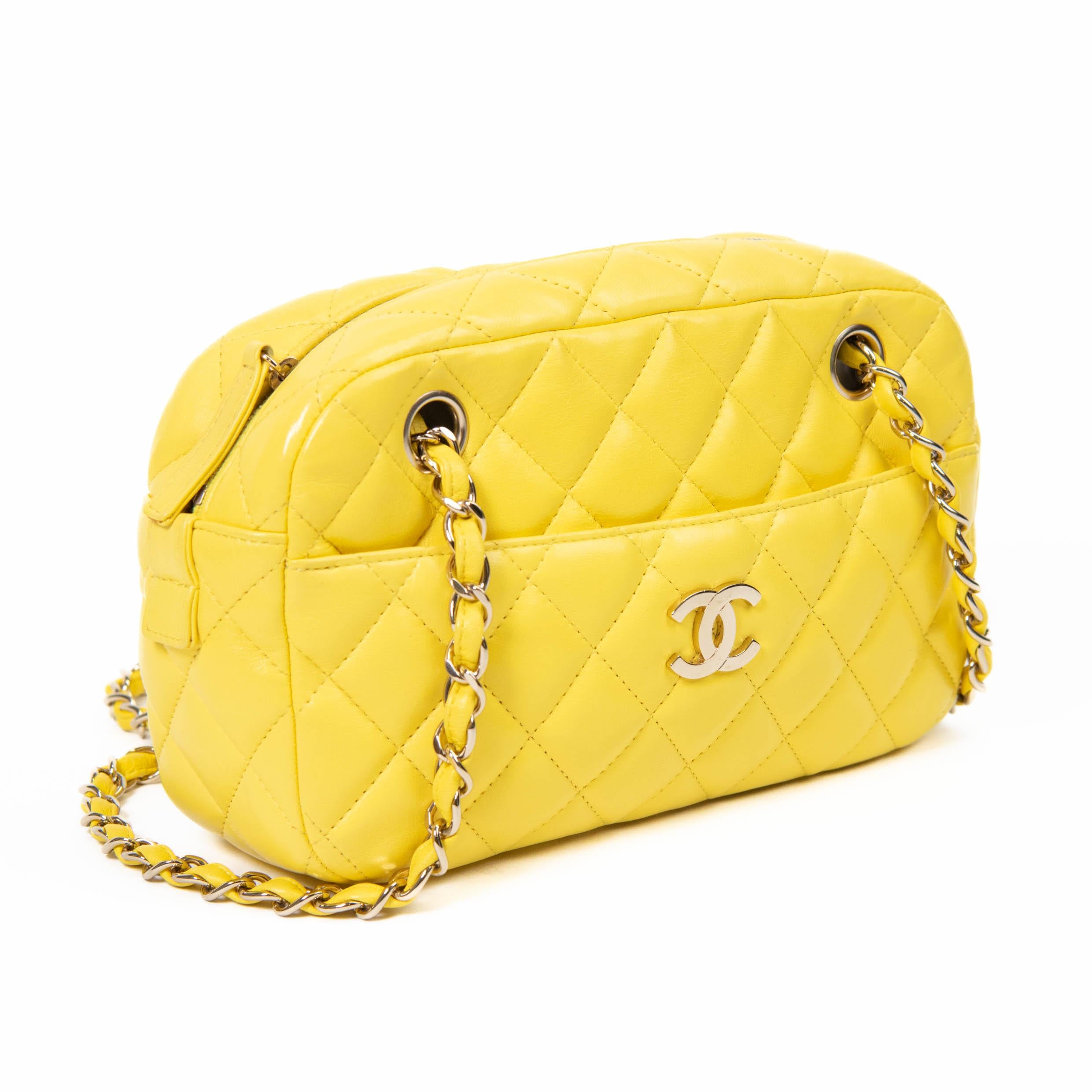 100% Authentic 

 This chic tote is crafted of luxurious diamond quilted lambskin leather in Yellow . The bag features Gold chain link handles threaded with Yellow leather and a frontal wide pocket with a Gold Chanel CC logo. The top zipper opens to