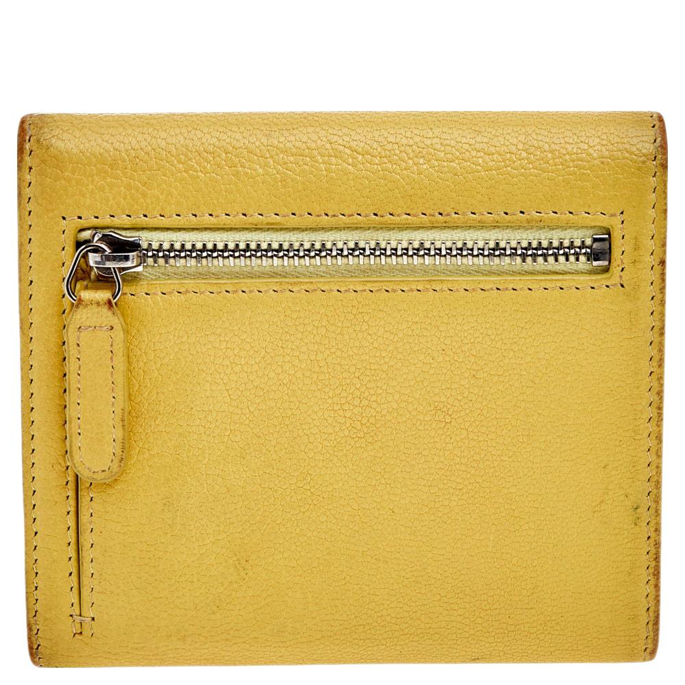 Petite in shape and classy in aesthetic, this wallet from the House of Chanel will certainly bring charming vibes to your everyday outfit. It is created from yellow leather, with a CC motif embellishing the front. The wallet has a trifold style,