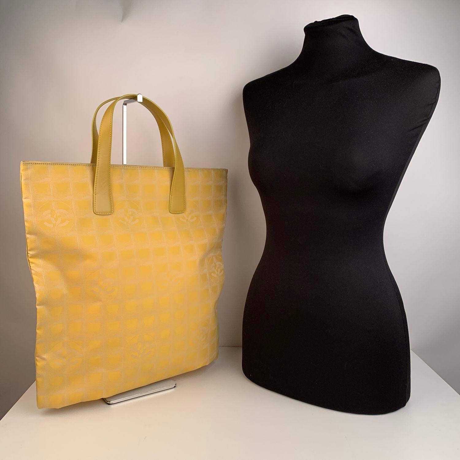 Chanel yellow jacquard nylon tote bag from the 'Travel line' collection. Yellow leather top handles.Double magnetic button closure on top. Yellow nylon lining with 2 side zip pockets inside. 'Chanel - Made in Italy' tag and authenticity hologram tag