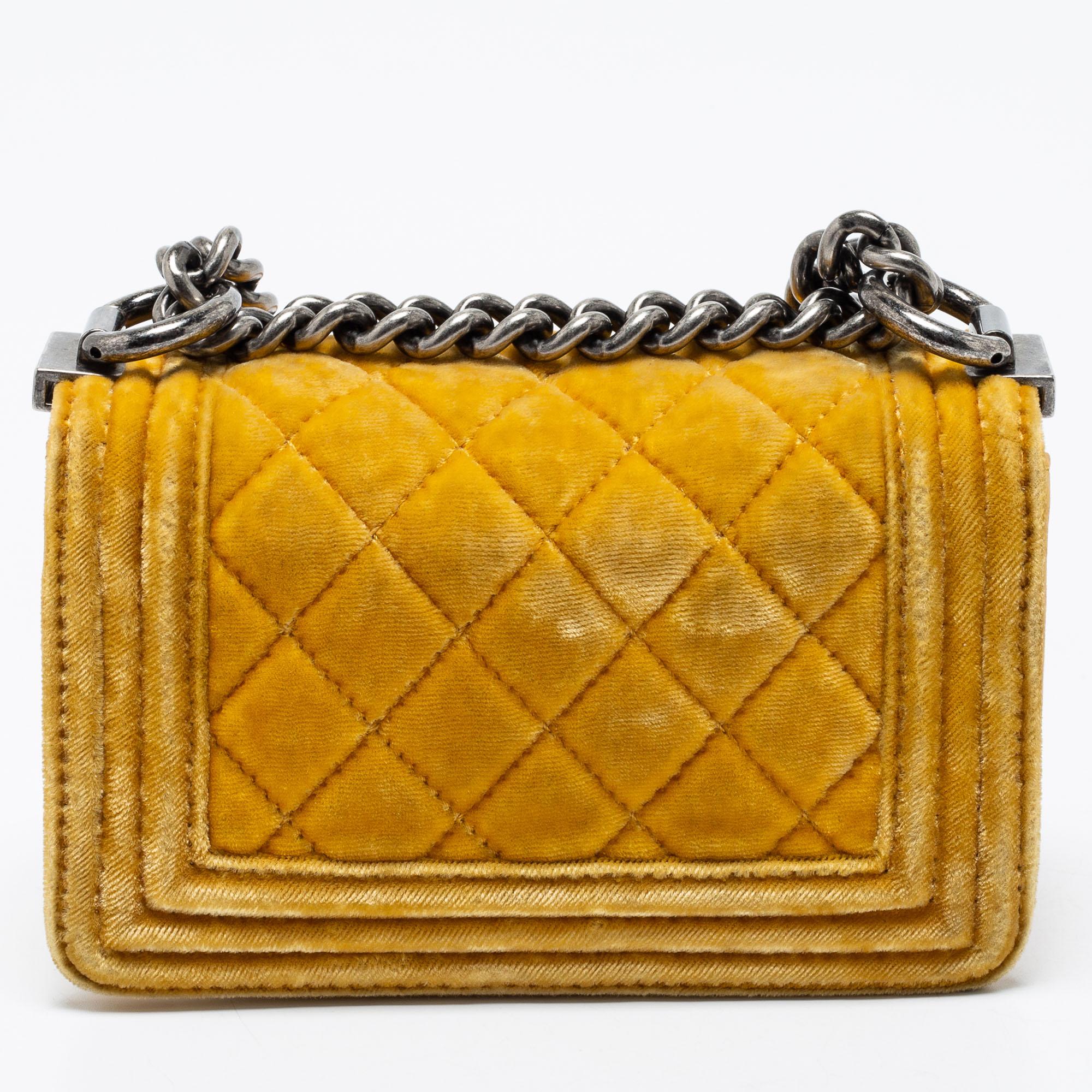 Introduced as a part of the Chanel Fall/Winter collection of 2011, the Boy flap bag is alluring and complemented with exquisite details. This yellow creation is meticulously crafted from quilted velvet and features side paneling, a chain-leather