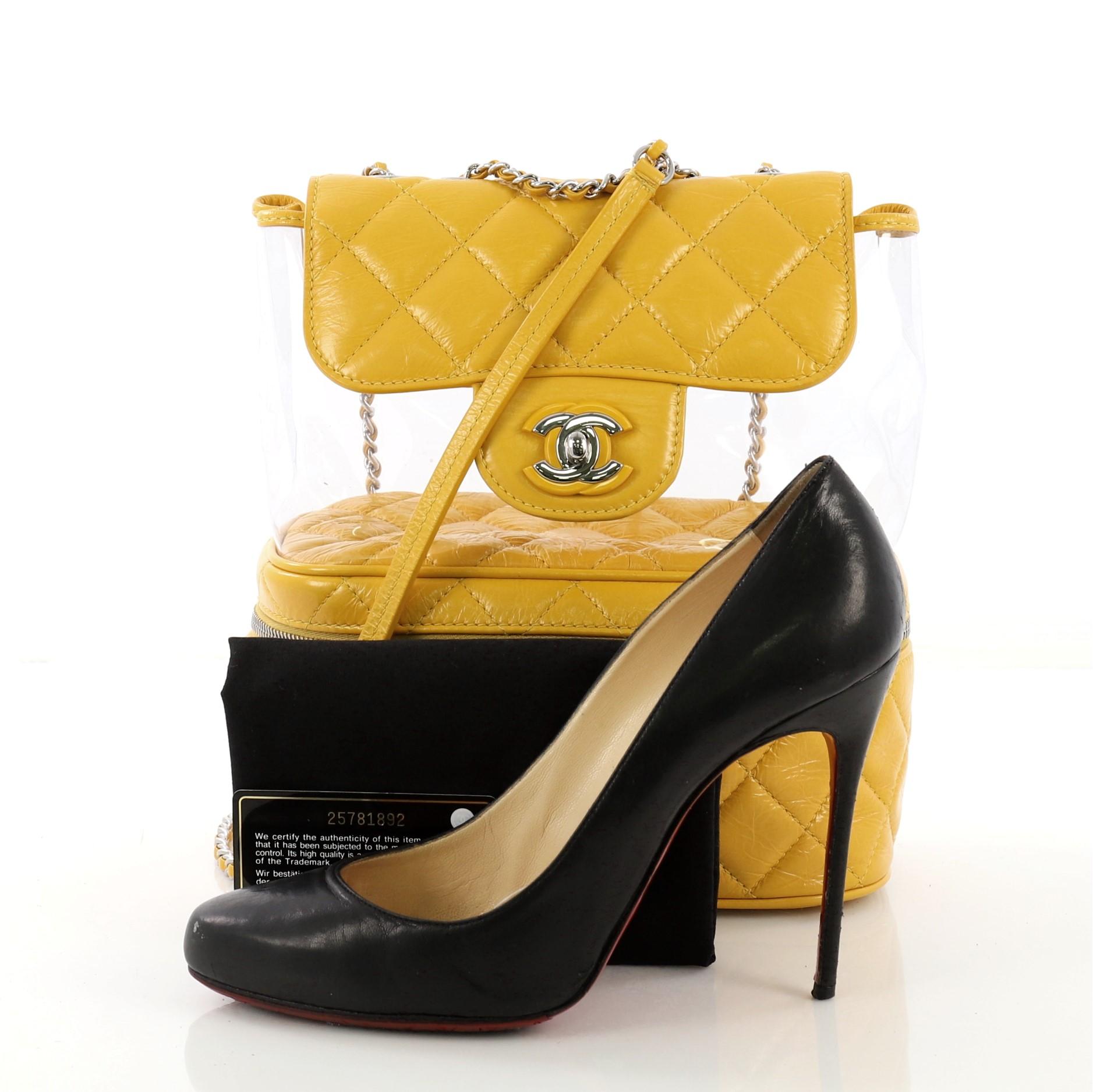 This Chanel Zip around Flap Bag Quilted Crumpled Calfskin and PVC Small, crafted from yellow quilted crumpled calfskin and clear PVC, features woven-in-leather chain straps, flap compartment with CC turn-lock closure, and silver-tone hardware. Its