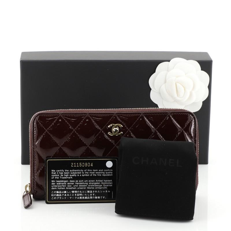 This Chanel Zip Around Wallet Quilted Patent Long, crafted from red quilted patent leather, features CC interlocking logo and aged gold-tone hardware. Its zip-around closure opens to a red leather and fabric interior with multiple card slots, middle