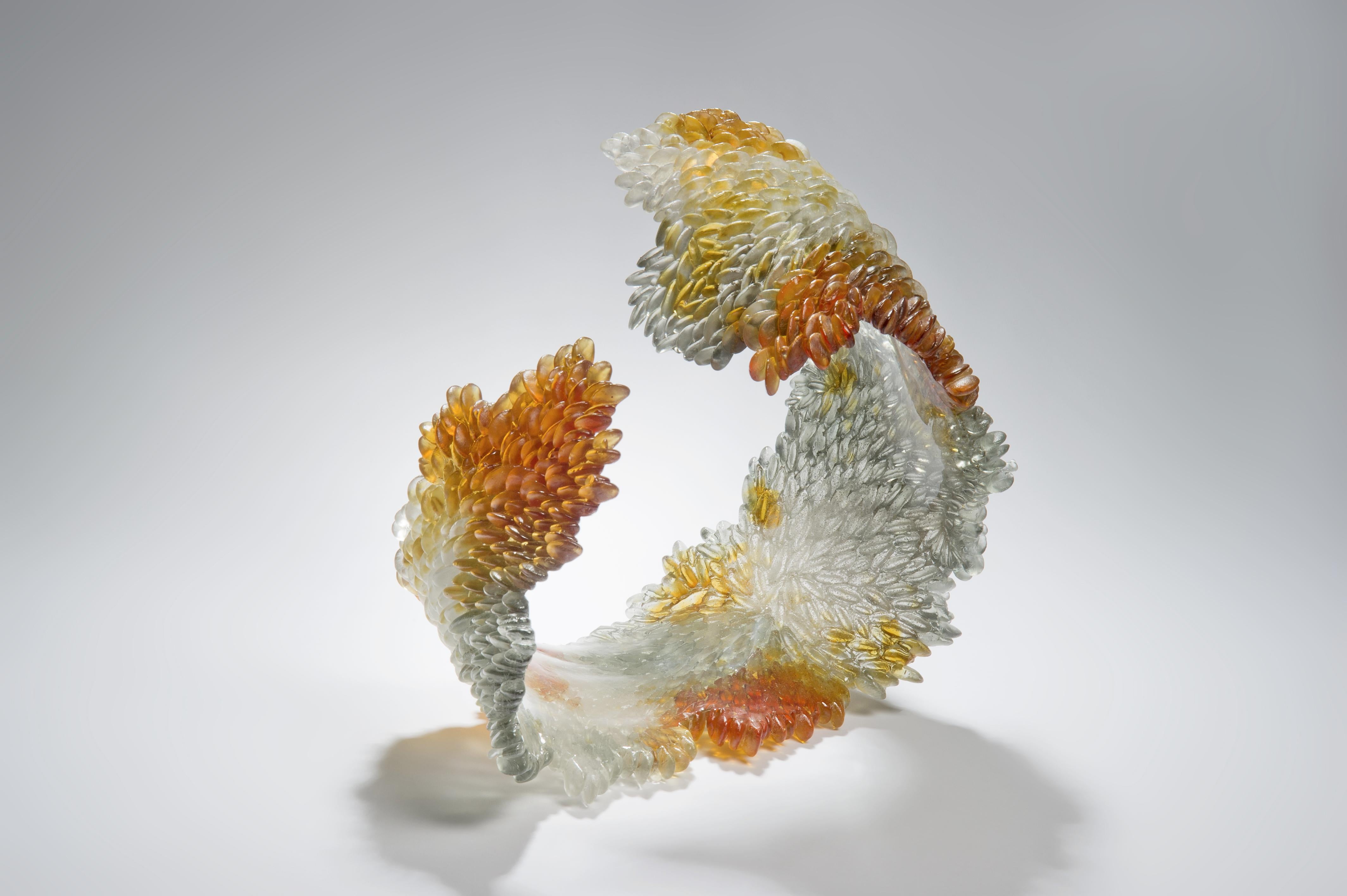 Changing colors is a unique textured glass sculpture in clear & amber by the British artist Nina Casson McGarva.

Casson McGarva firstly casts her glass in a flat mould where she introduces all of the beautifully detailed, scaled surface texture,
