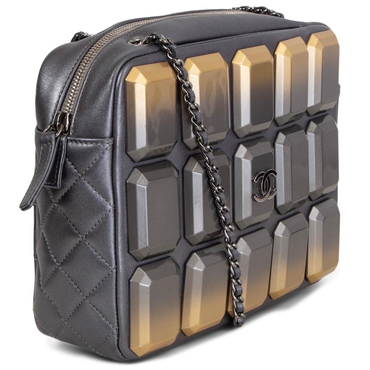 100% authentic Chanel 2014 Art Camera shoulder bag in dark metallic pewter grey quilted leather. The front is covered in faceted resin rectangles in a gold to smoky grey degrade. Zippered top accesses to the grey grosgrain fabric interior with one