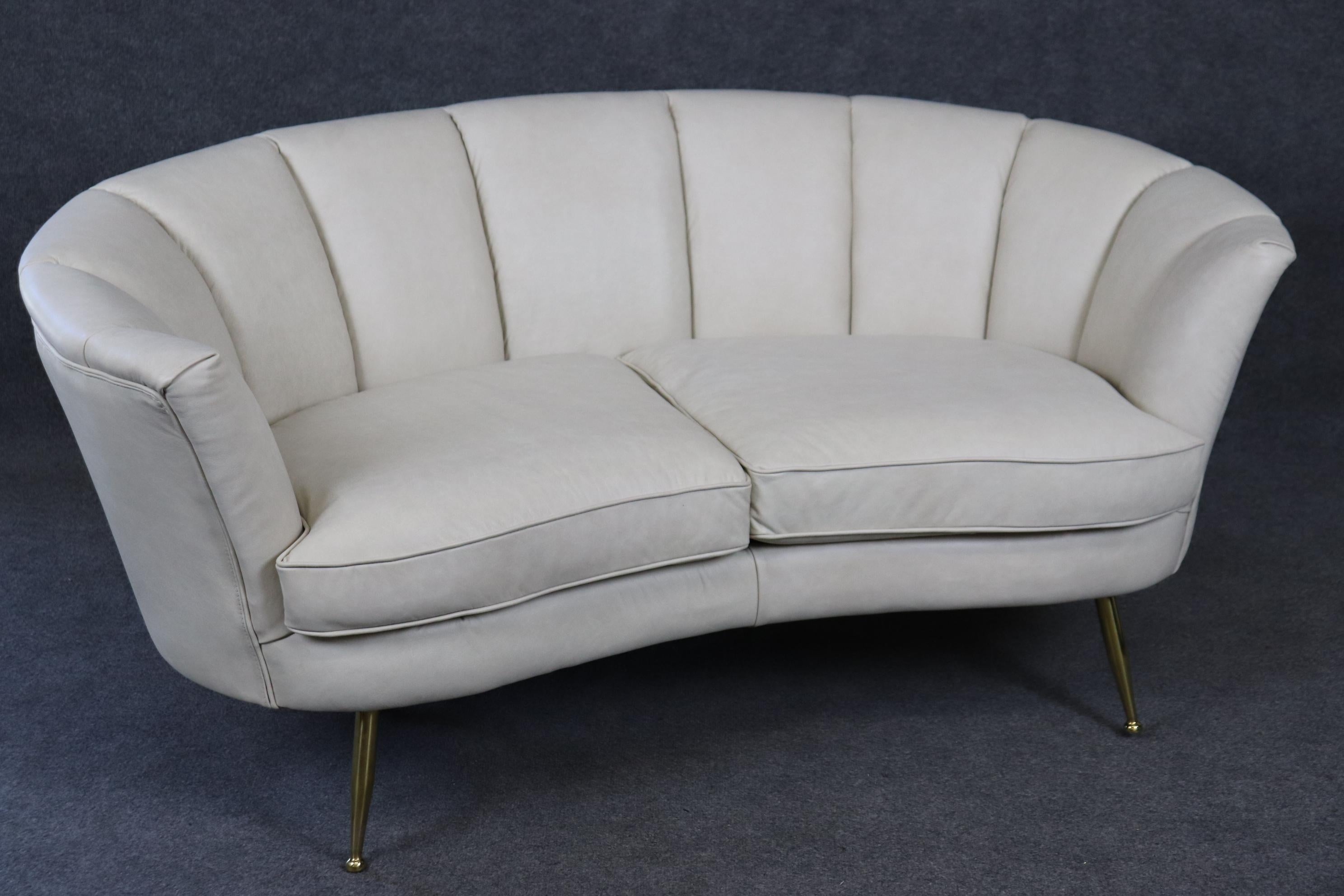 This is a super leather channel back upholstered Italian mid century modern canape or sette with solid brass legs. The piece dates to the 1950s era and has been restored. Good used condition. Measures 64 wide x 30 deep x 29.25 tall and seat height