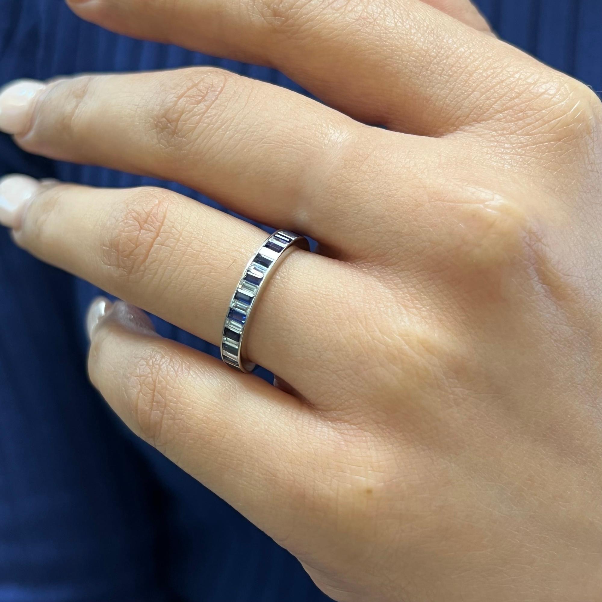 This beautiful eternity band ring features baguette cut scintillating blue sapphires and baguette cut sparkling diamonds. Alternatively secured in channel setting. Crafted expertly in Platinum. Arranged in a full eternity and offer a spectacular