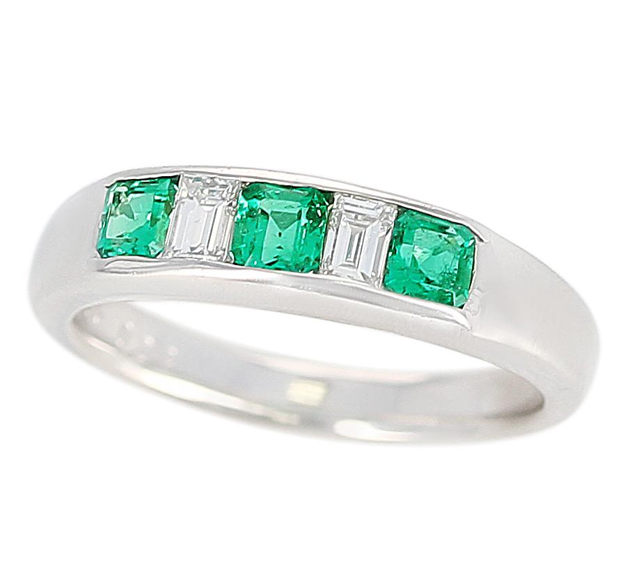 A Channel-Set Invisible Emerald and Diamond Platinum Bridal Ring. Diamond Weight: 0.29 carats, Emerald Weight: 0.53 carats. Total Weight: 8.05 grams. Ring Size US 7.75.