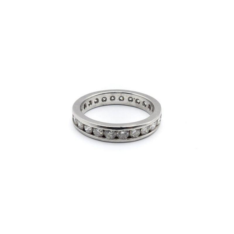 This Mid-Century Modern eternity band consists of 24 round brilliant-cut diamonds channel set in platinum. The diamonds are bright and lively, VSII-SLII in clarity and G-H in color. The perforated interior band allows the stones to nestle securely