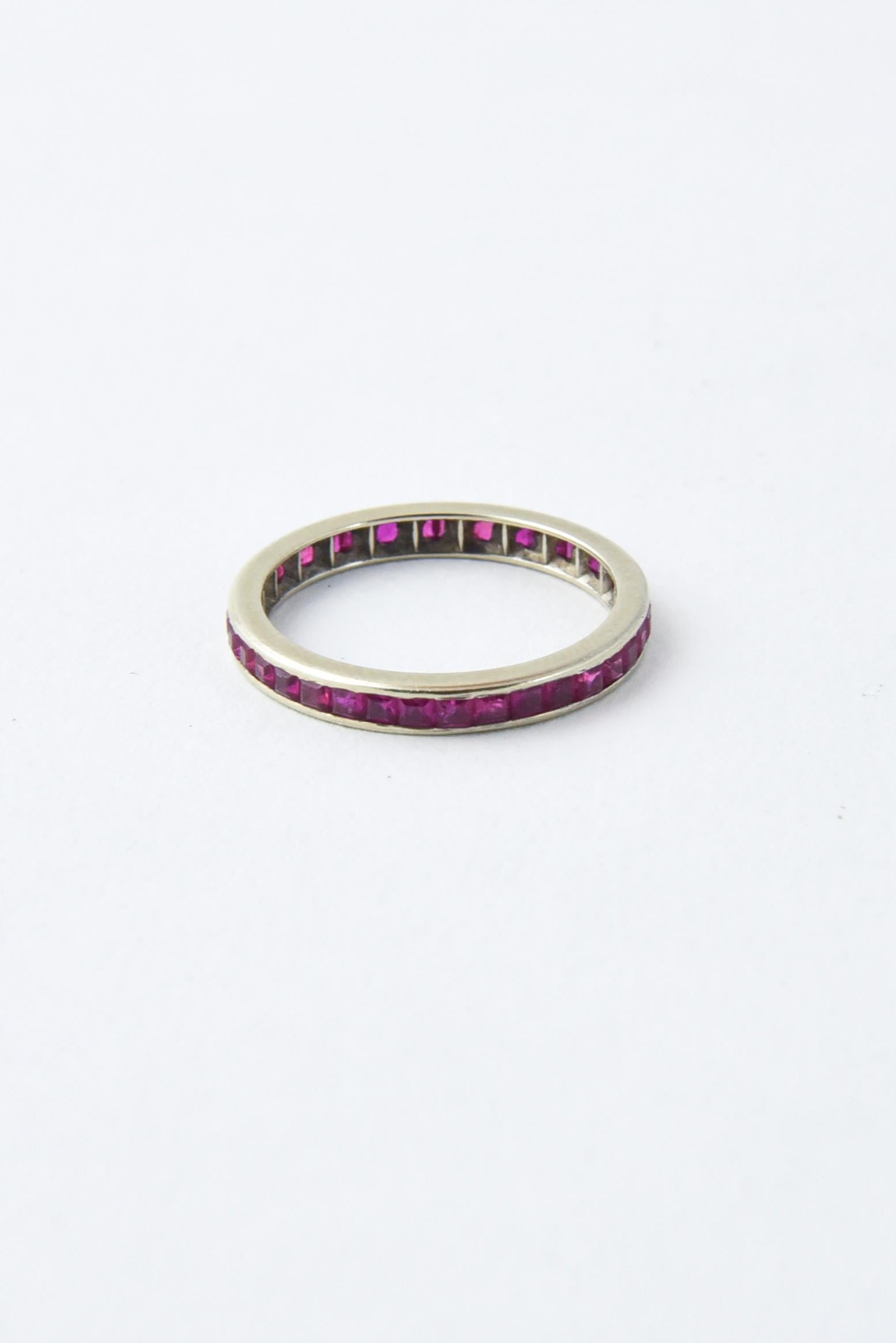 14K white gold eternity band featuring channel-set calibre square step-cut rubies. US size 7; cannot be sized. Abrasions on stones, scratches and wear to gold.
