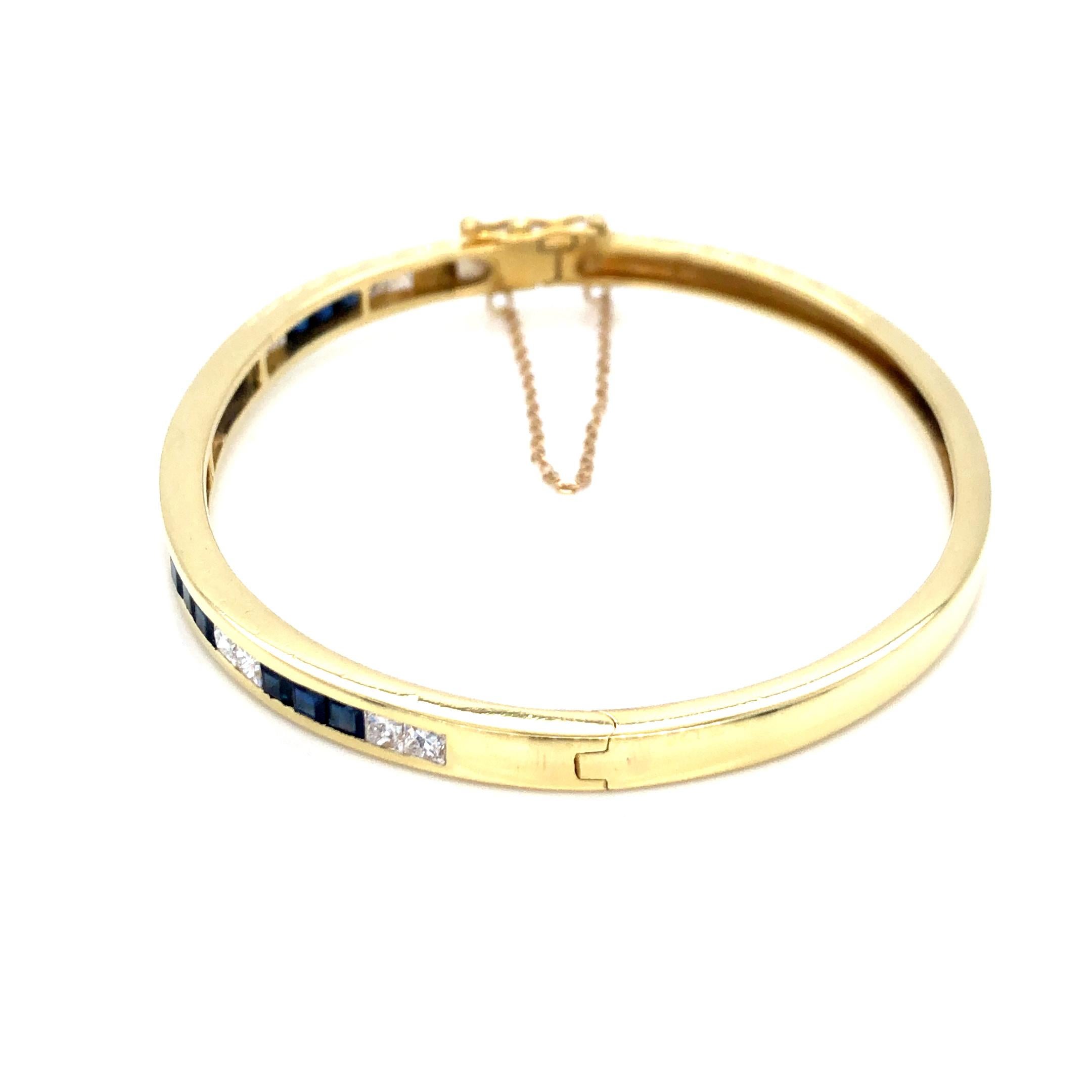 Channel Set Sapphire and Diamond Bangle in 18K Yellow Gold. The bracelet features 15 square cut blue sapphires and 12 square cut diamonds. Diameter 6.75 inches.
19.27 Grams
4.85mm Wide