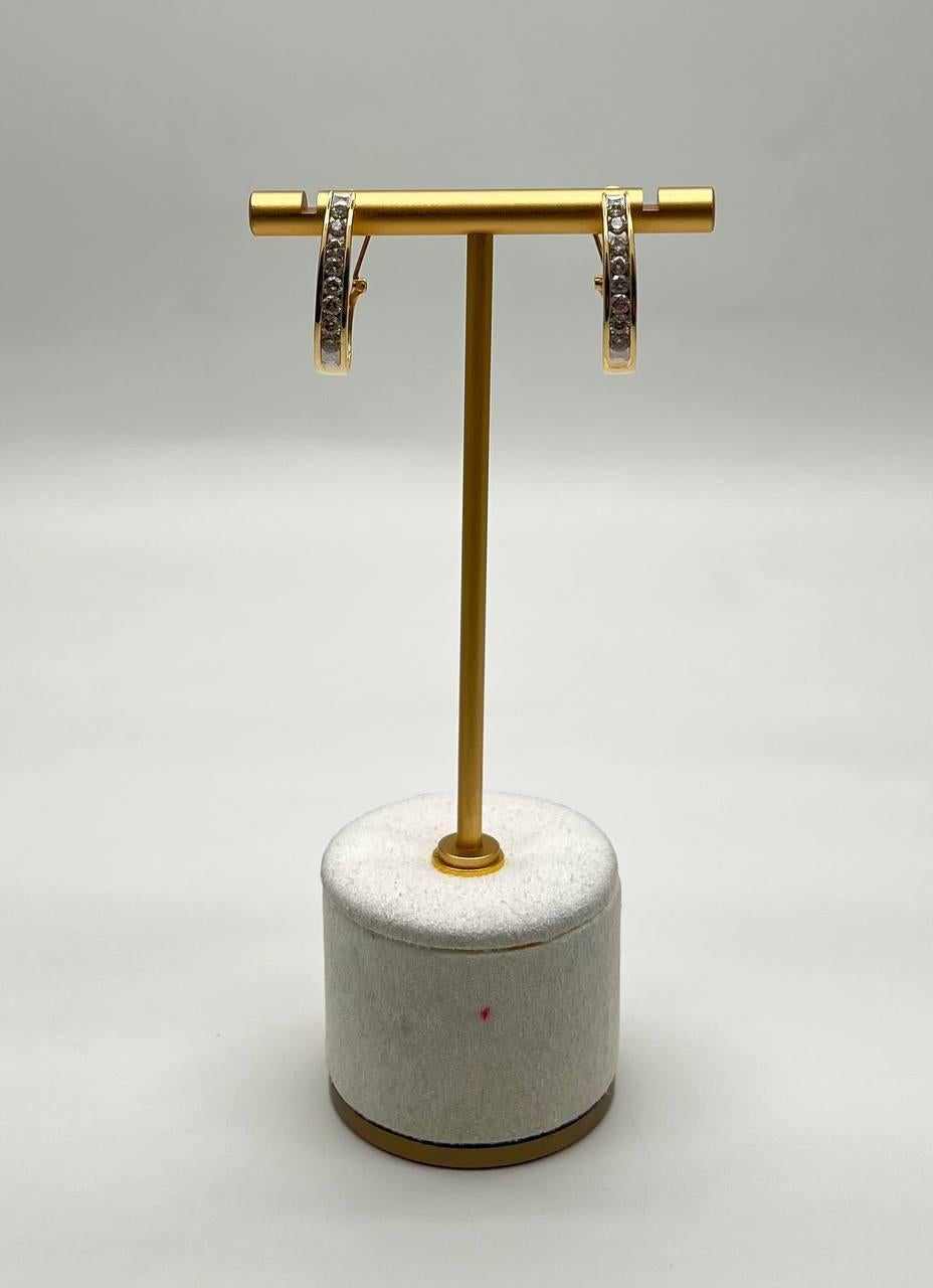 These earrings feature a sleek design with sparkling diamonds set in a polished metal finish. The earrings are in excellent condition and exhibit a refined, modern aesthetic. 14K Yellow Gold. 1.00 CTW Diamonds.