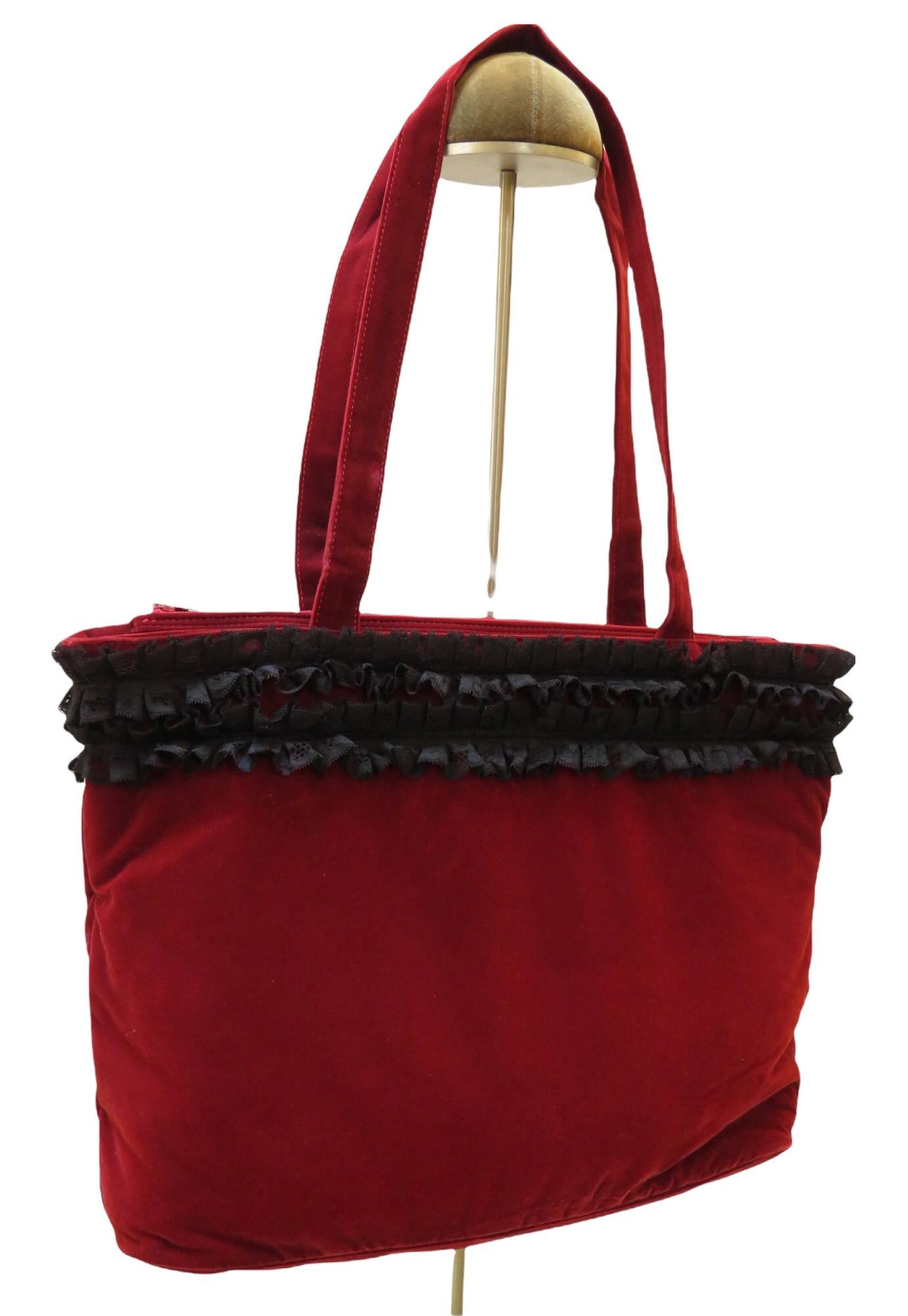 Vintage Chantal Thomass zippered red velvet shoulder bag with two straps. Playful black lace ruffle trim surrounds. Inside there is one red velvet  zippered pocket that stands out against the black quilted lining.