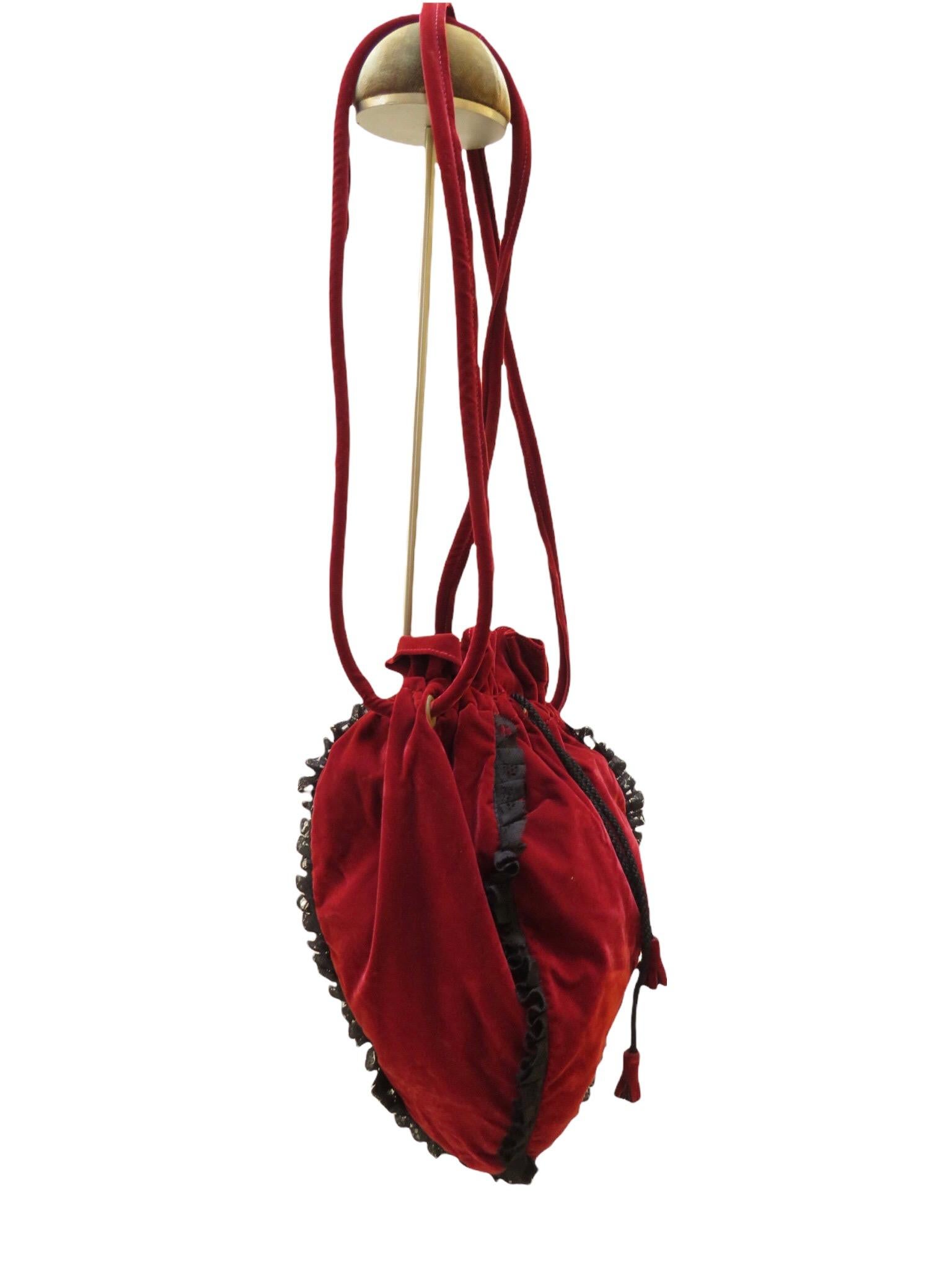A double strapped red velvet drawstring pouch shoulder bag comes from vintage Chantal Thomass, with black lace ruffle edging and a satin cord drawstring with red leather pulls. Once inside, you'll be treated to plenty of storage with a special black