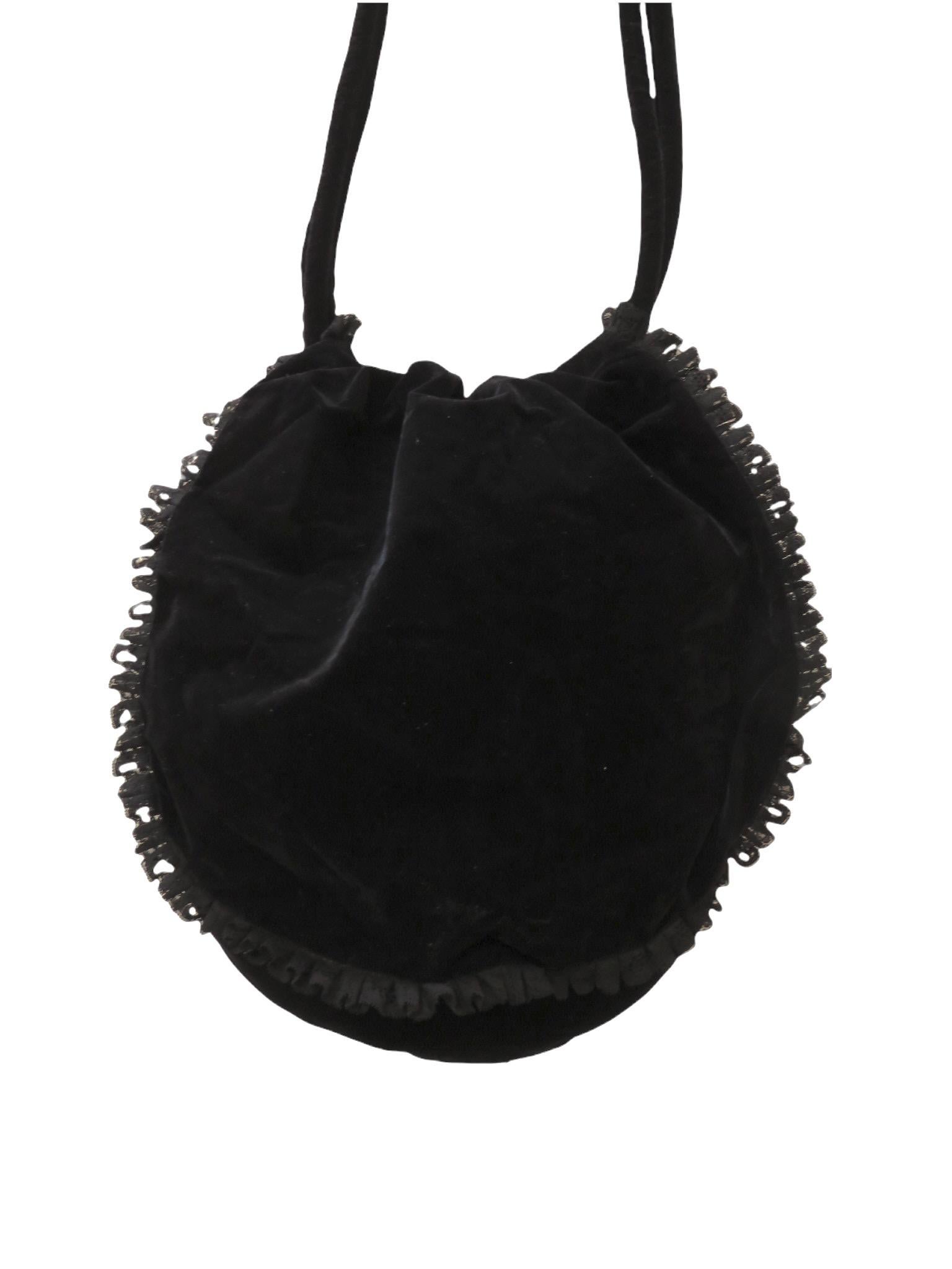 An ample handbag from vintage Chantal Thomass is constructed of soft black velvet. The flap features black lace ruffle embellishments. Beneath the flap is a deep pouch secured with a black drawstring cord. Carry it with confidence as you shoulder