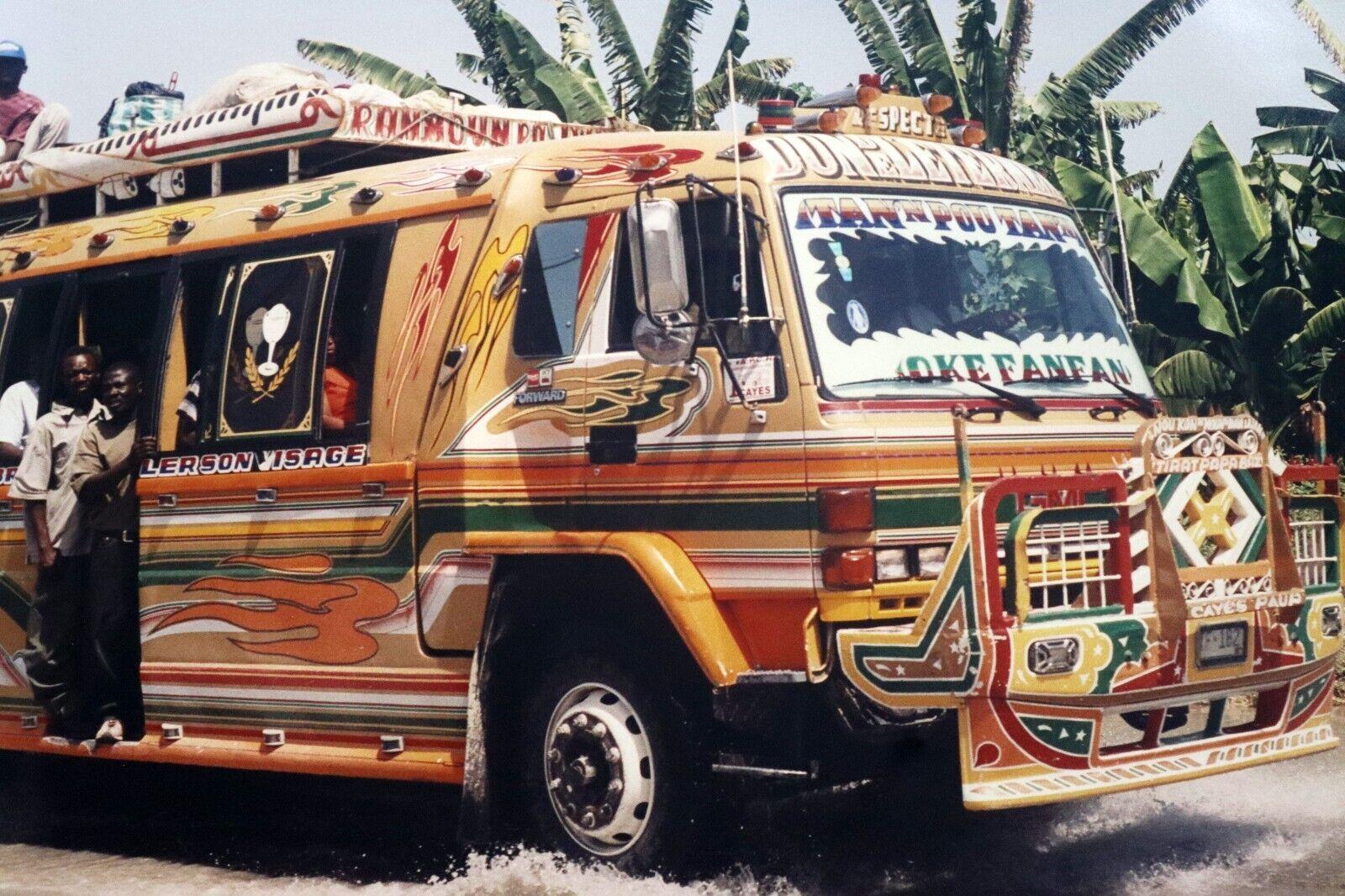 A rich, vibrant, contemporary photograph depicting a Haitian colorful bus by award winning photographer Chantel James. Dimensions: 16h x 22w (framed). In excellent condition.

Chantal James is known for being included in the award-winning travel and