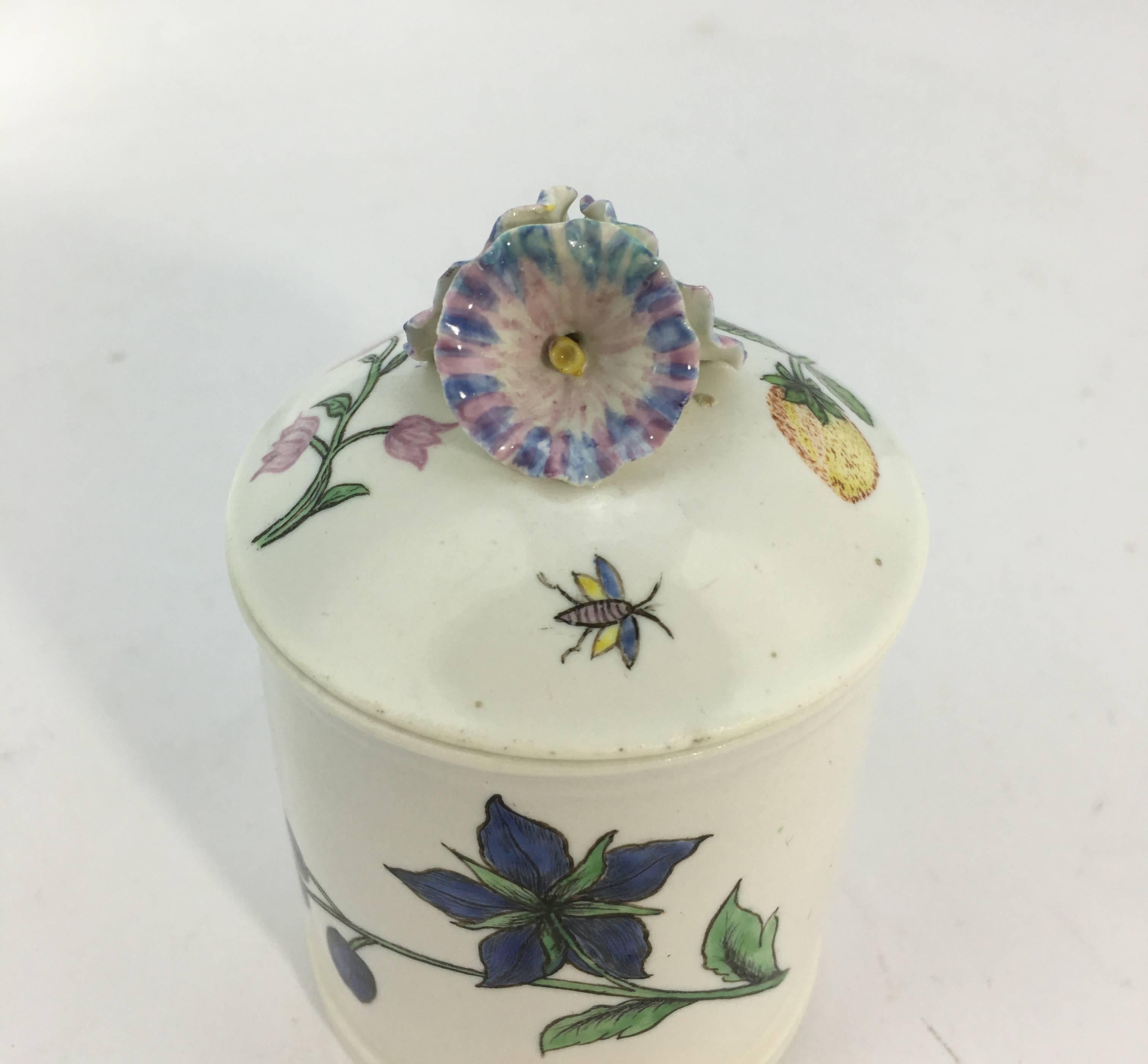 Chantilly pomade pot with straight sides and domed top, decorated with rare Holzschnittblumen (woodcut flowers) after Meissen originals of the 1730s, the lid as 'morning glory' flowers and painted with a bee, strawberries and a flower sprig.
 
