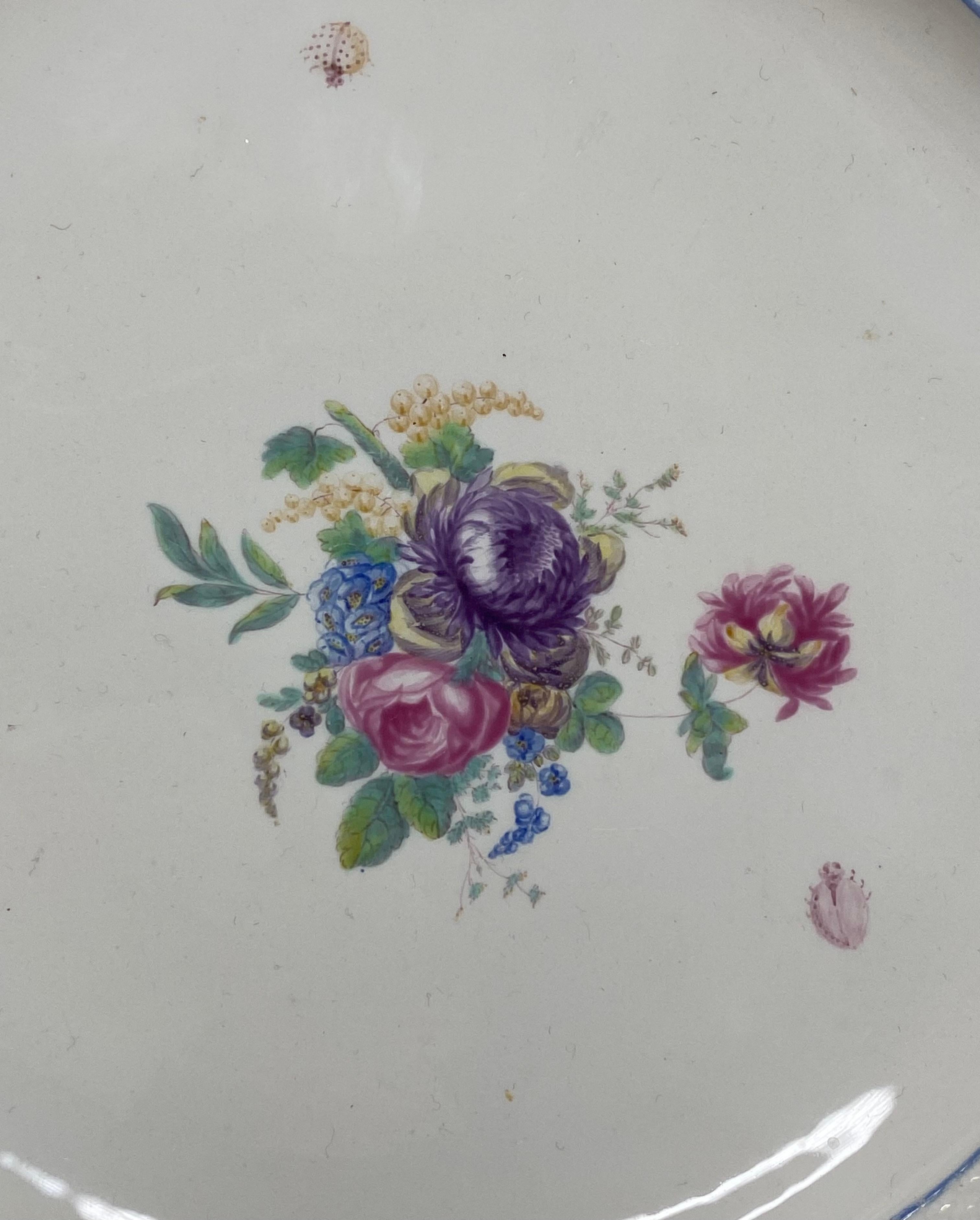 Chantilly porcelain plate, France, c. 1755. The plate, hand painted to the centre, in soft tones, with a spray of flowers, and three insects.
Having an osier moulded border, within a lobed rim.
Puce hunting horn mark to the reverse.
Diameter – 24
