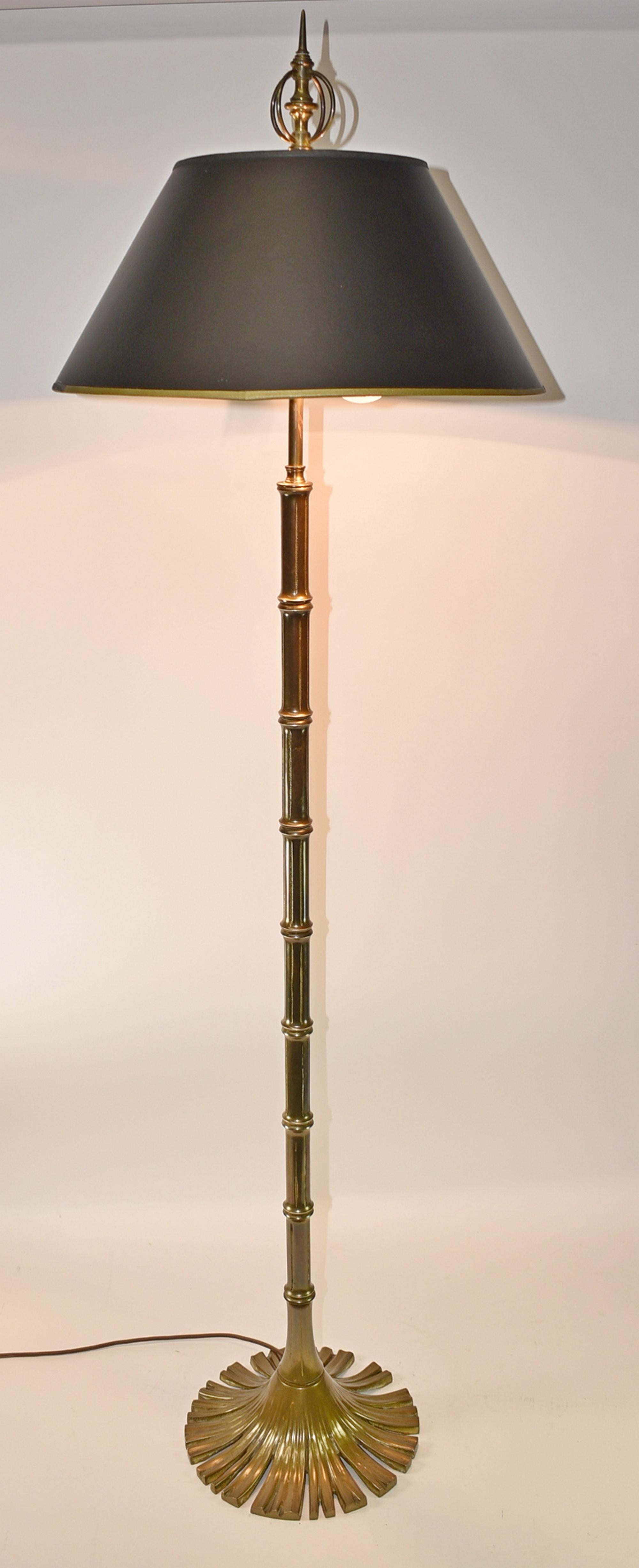 Chapman brass bamboo floor lamp, Circa 1976. Cast brass lamp with bamboo details. Base is fan shaped circle of reeds. Original sockets with tag dated 1976. Two sockets with pull chains. Comes with shade that has black and gold stippled interior.