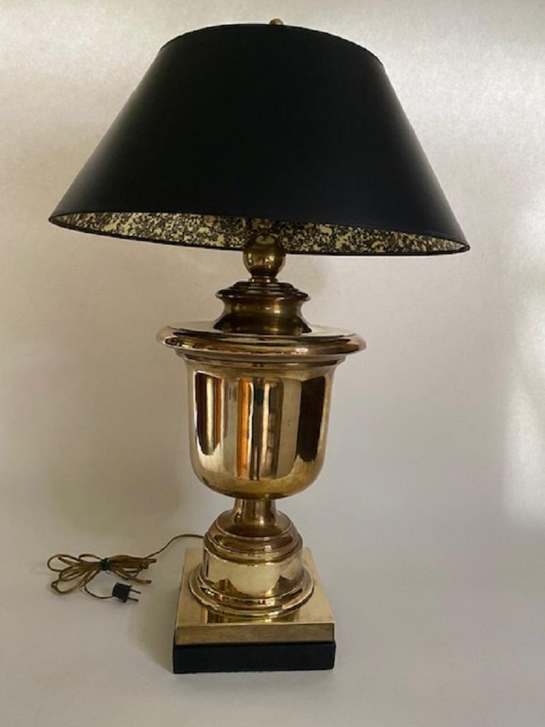 Magnifique lampe de table en laiton de Chapman. La forme d'urne en laiton massif est agrémentée d'un socle carré noir et d'un abat-jour en parchemin noir, le tout surmonté d'un épi de faîtage en laiton surdimensionné.  La lampe et l'abat-jour sont