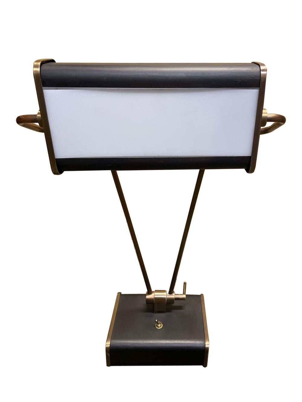 a quality lamp made by Chapman Manufacturing Company,  USA, the swivel shade fitted with a standard socket and frosted glass panel raised on adjustable brass arms all over a rectangular base mounted with a toggle switch